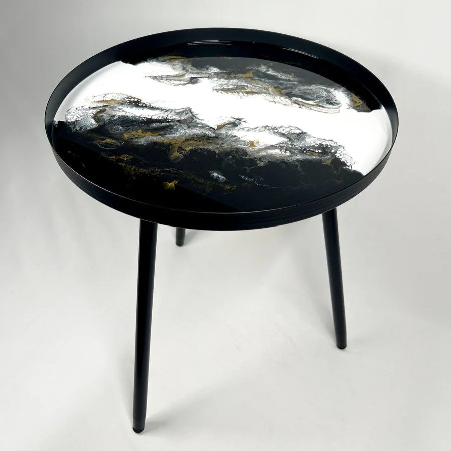 Round resin black table with artistic design on a white background