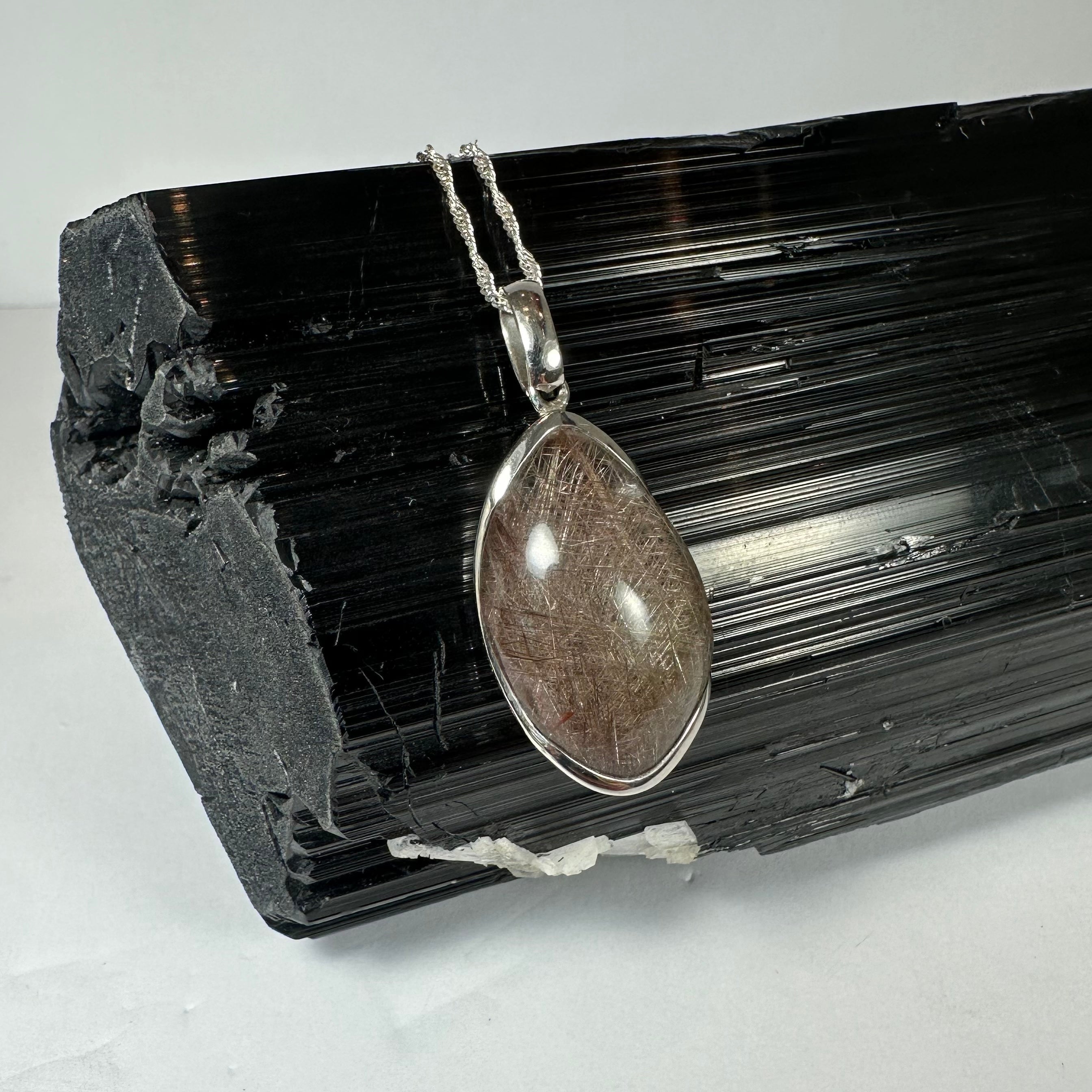 Silver Rutile Teardrop Pendant showing freeform quartz cabochon with needle-like inclusions set in sterling silver clasp