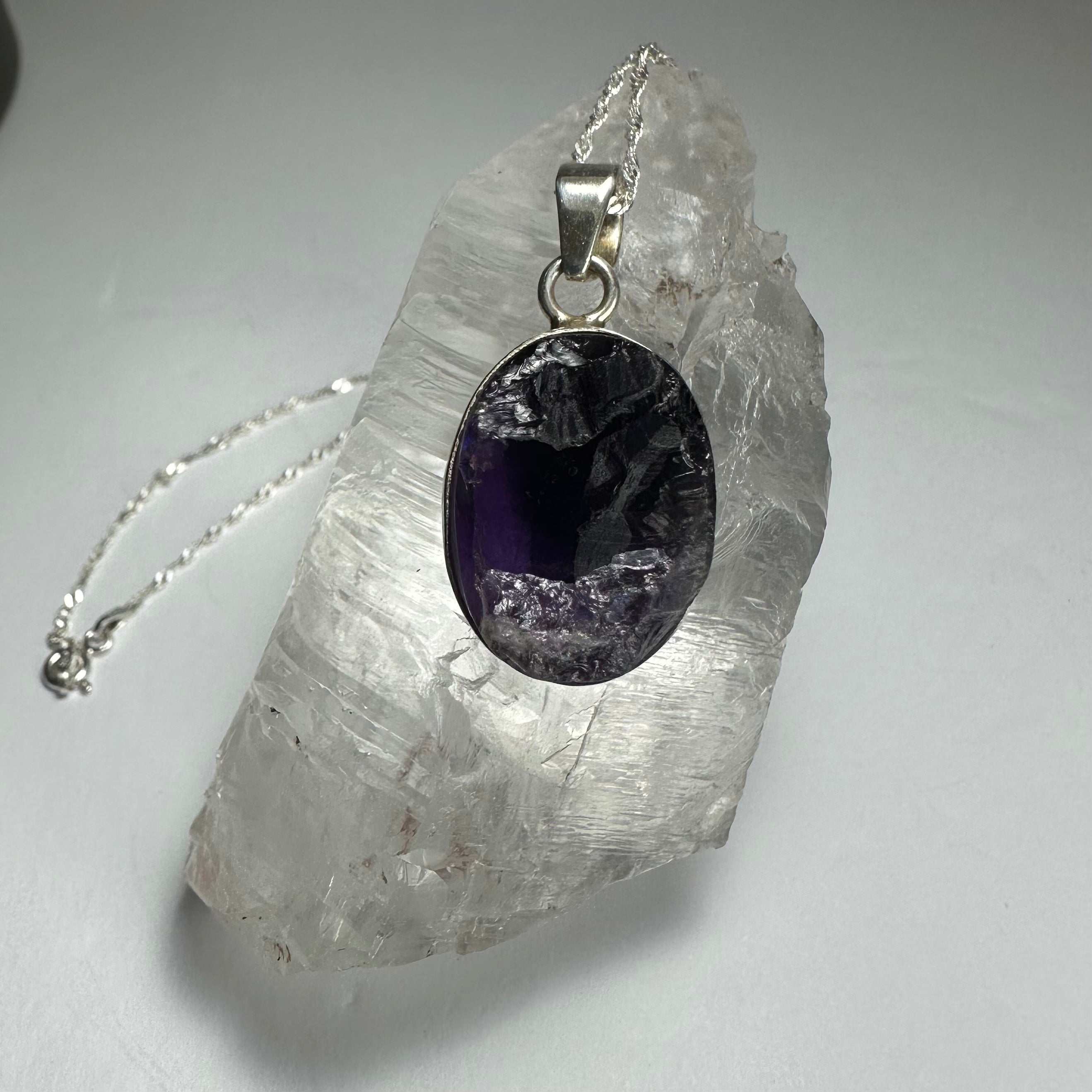 Natural rough amethyst pendant with dark purple stone and silver clasp