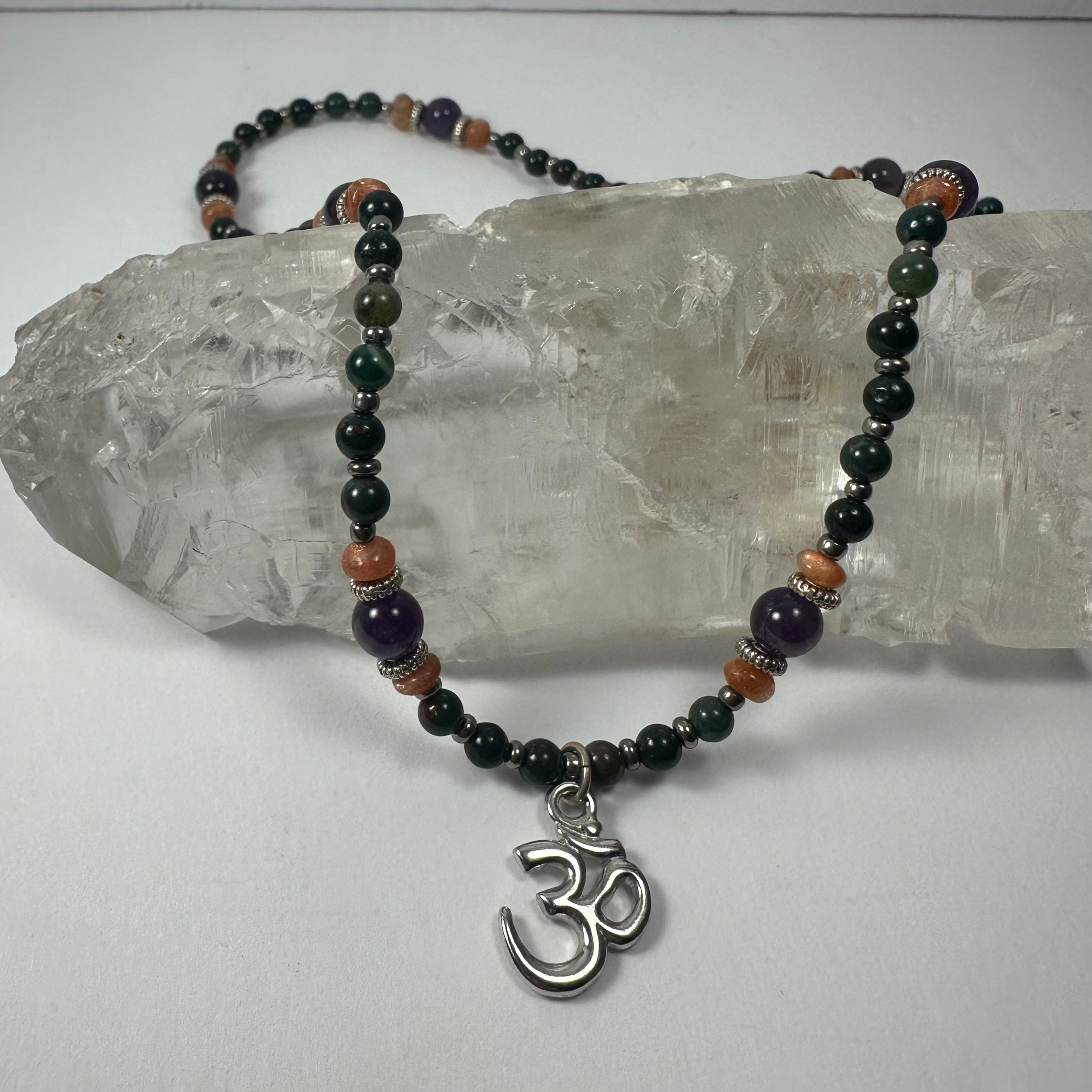 Handmade Bead Necklace with Silver 'Om' Pendant showing purple and orange beads with silver Om charm