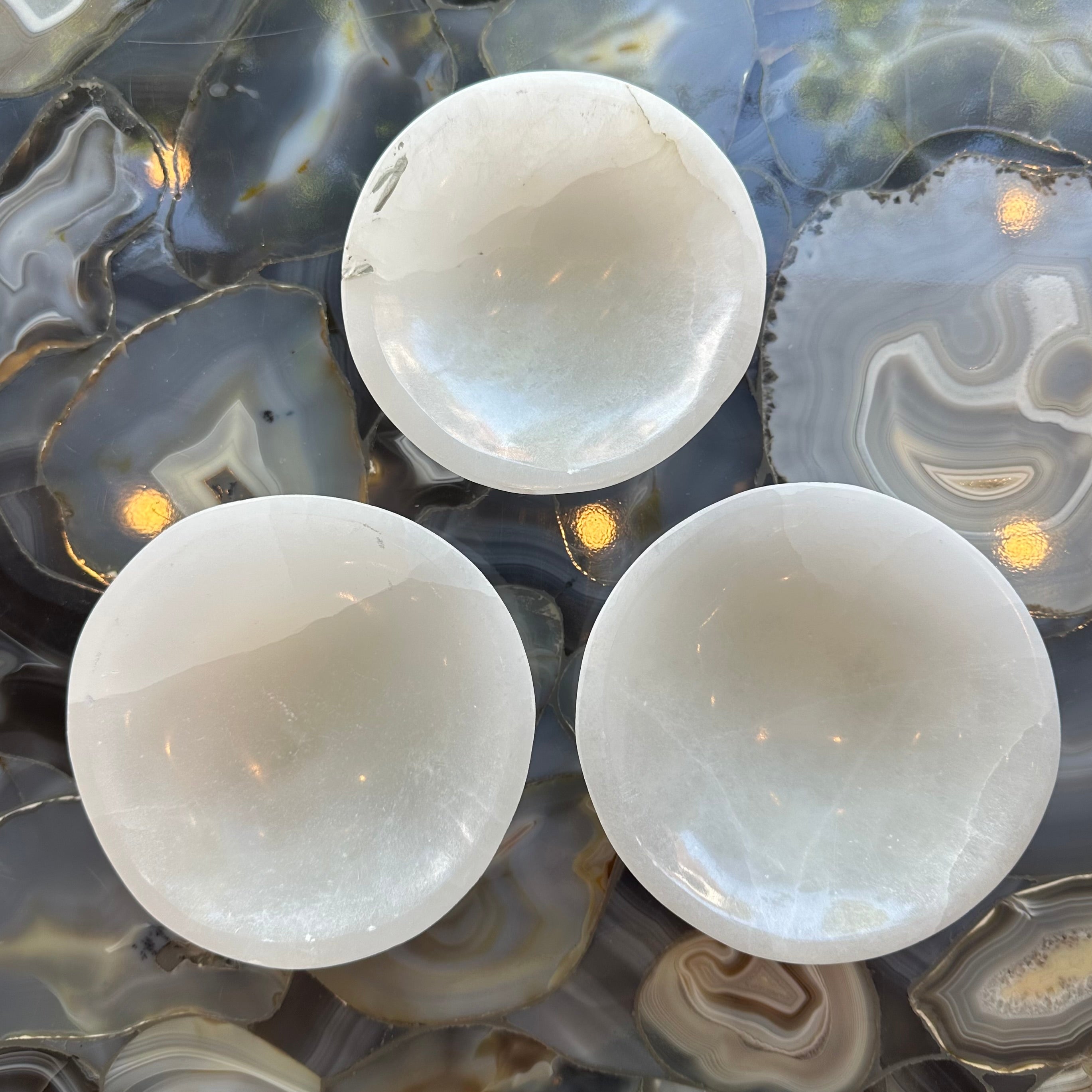White selenite bowl with natural striations, softly glowing under natural light