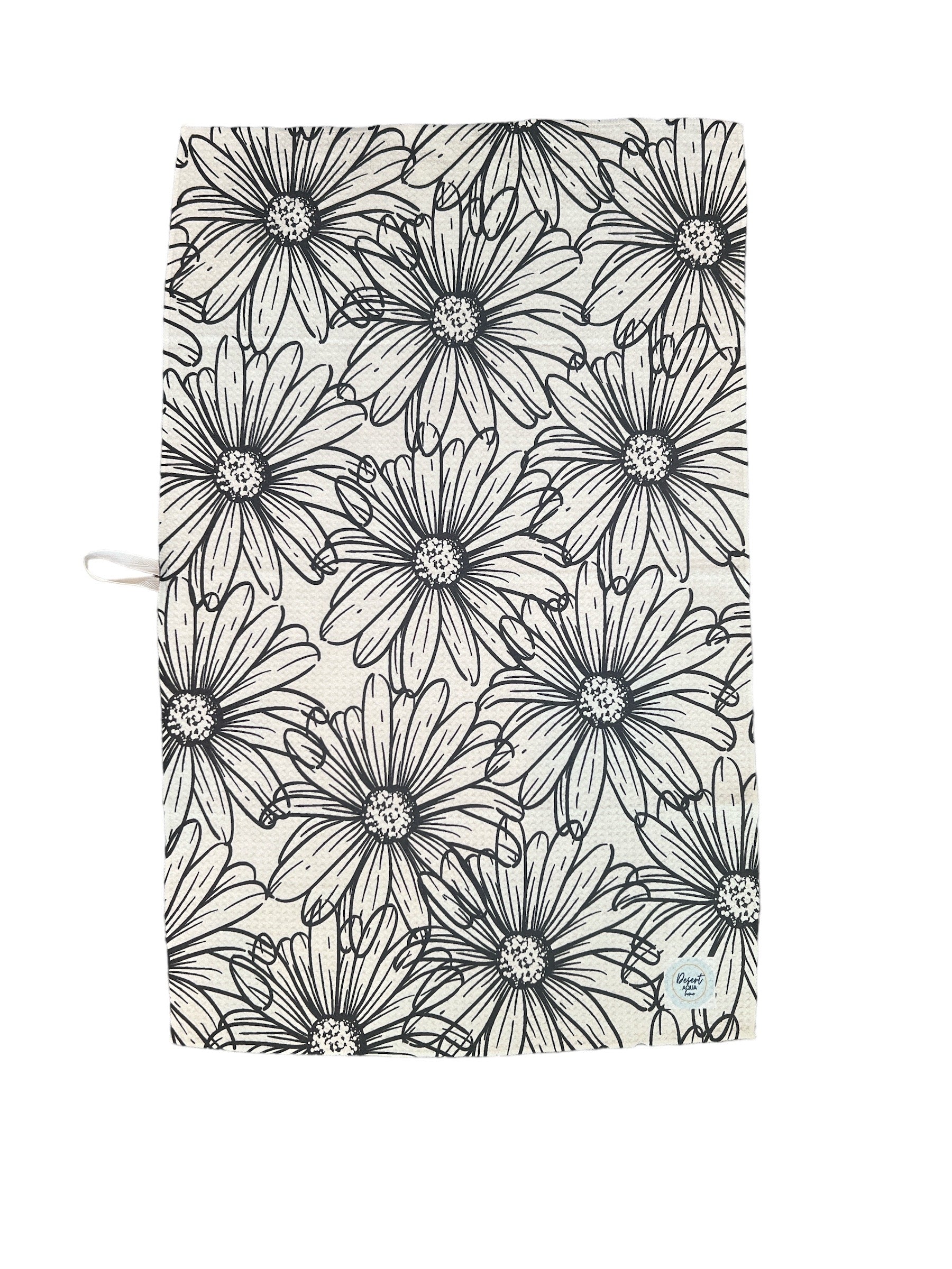 Drawing Daisies Kitchen Towel hanging with beige and black floral print visible