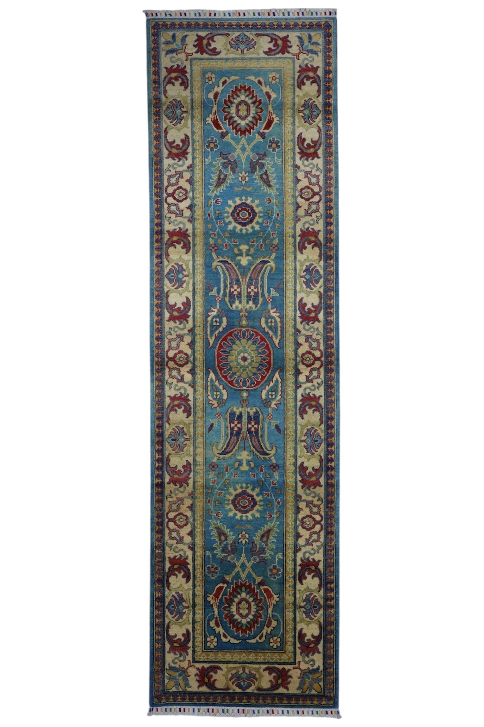 Hand-knotted Afghani Kazak wool rug in blue and cream laid on wooden floor
