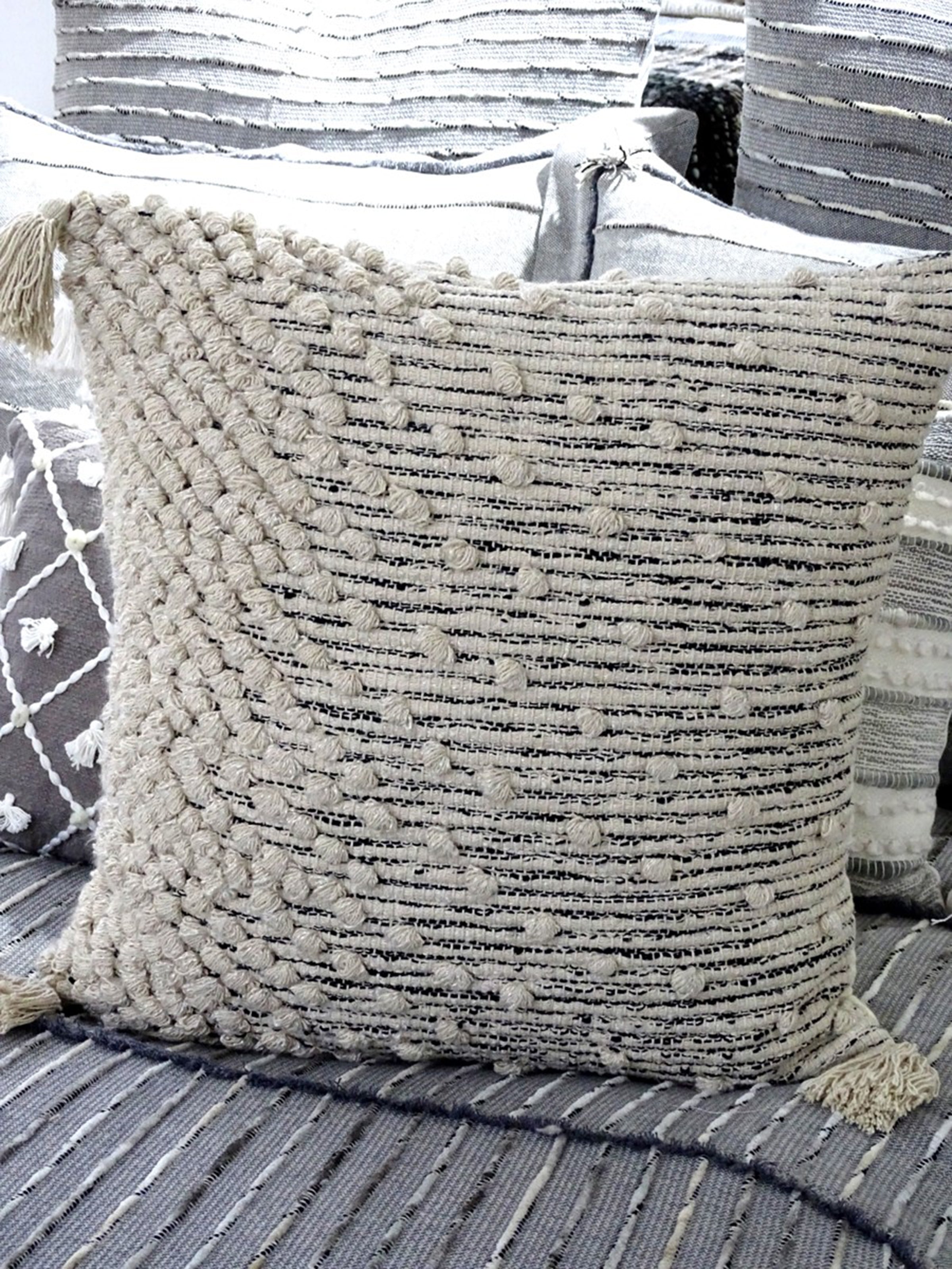 Beige woven throw pillow cover with insert, styled on a wooden slatted surface