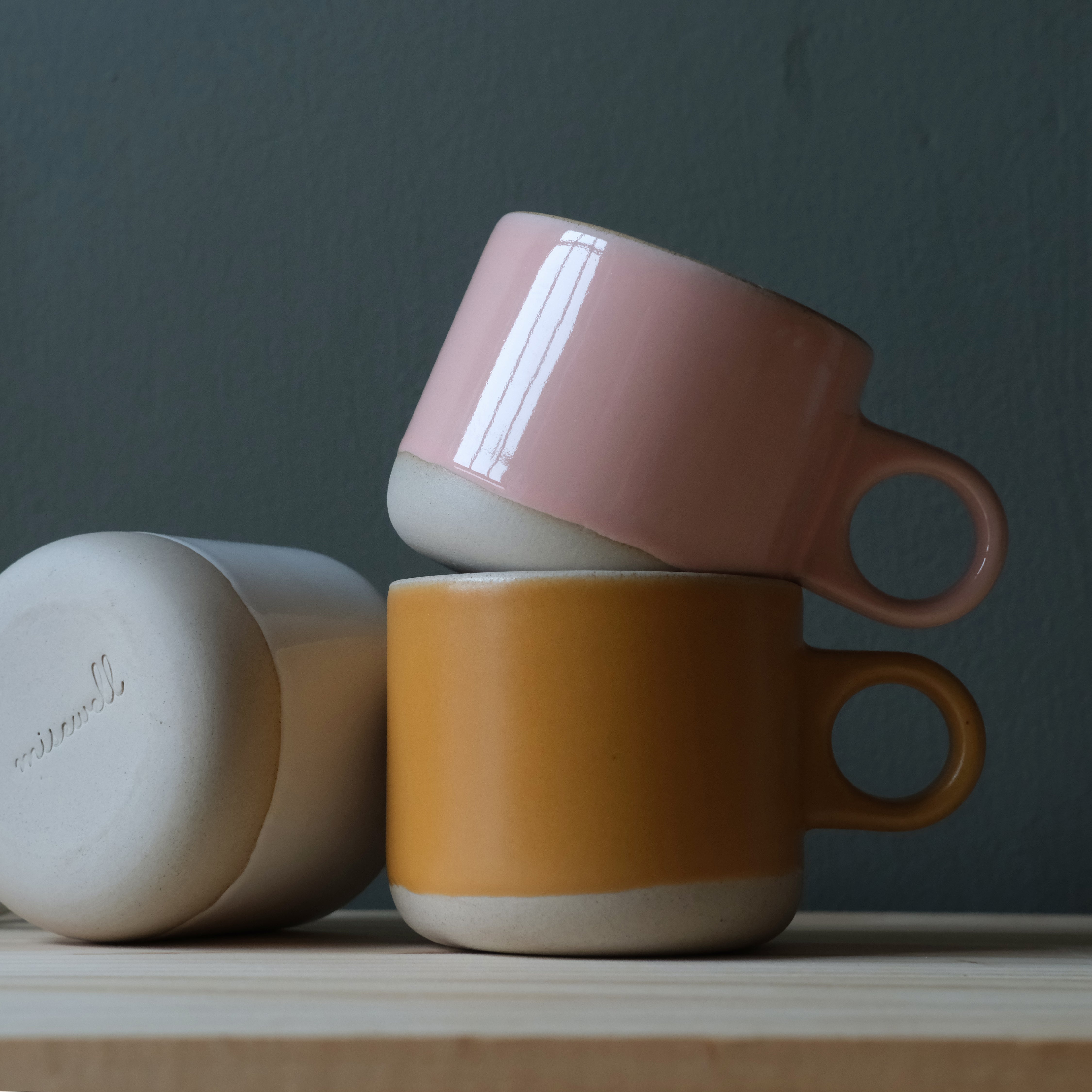 Scotty Mug with gold dipped handle and pink glossy glaze on wooden surface