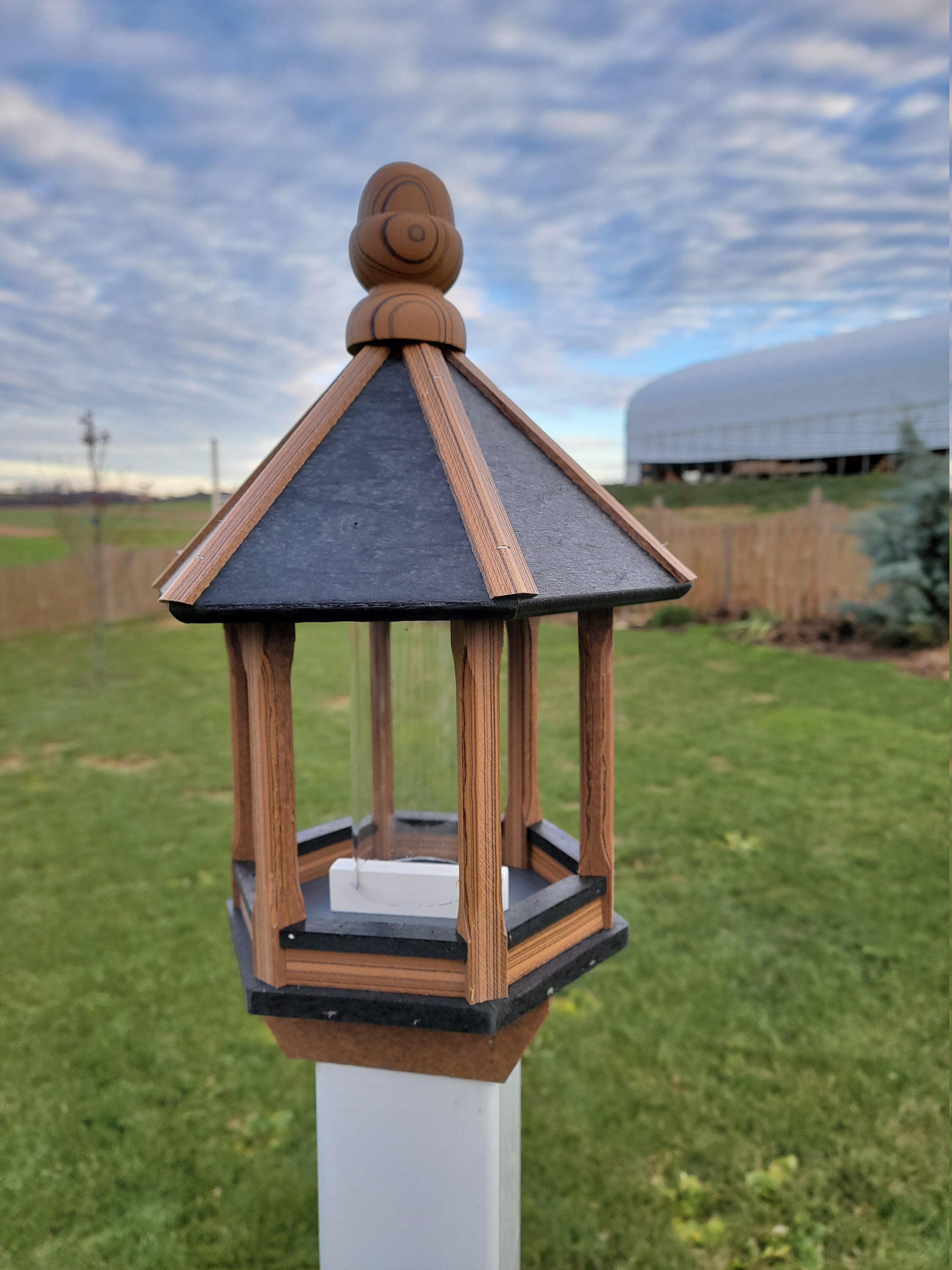 Amish handmade poly bird feeder with rustic spindle design, shown mounted outdoors