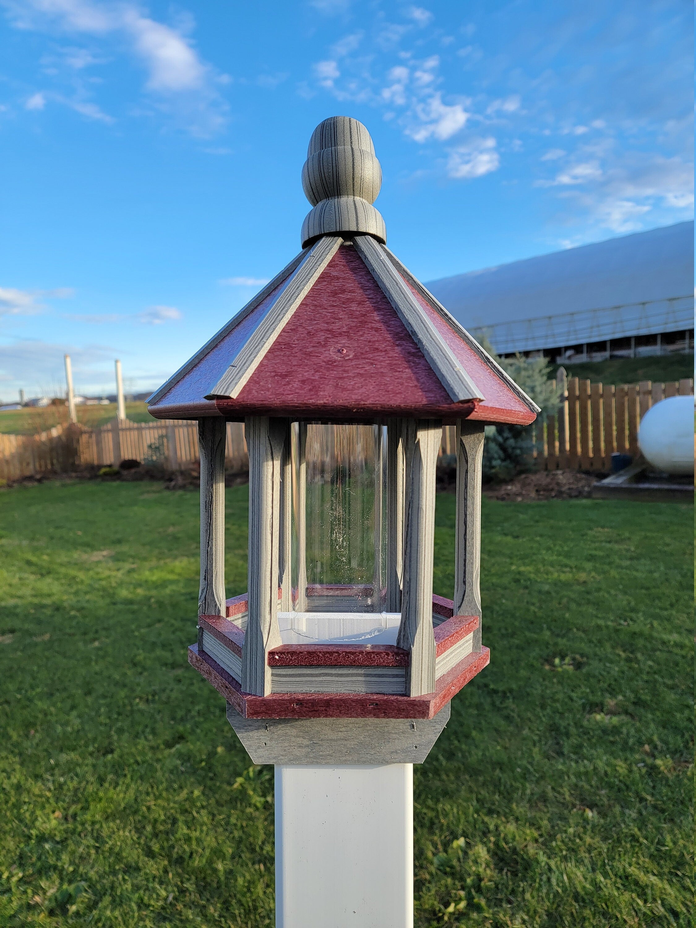 Amish handmade poly bird feeder with rustic spindle design, shown mounted outdoors