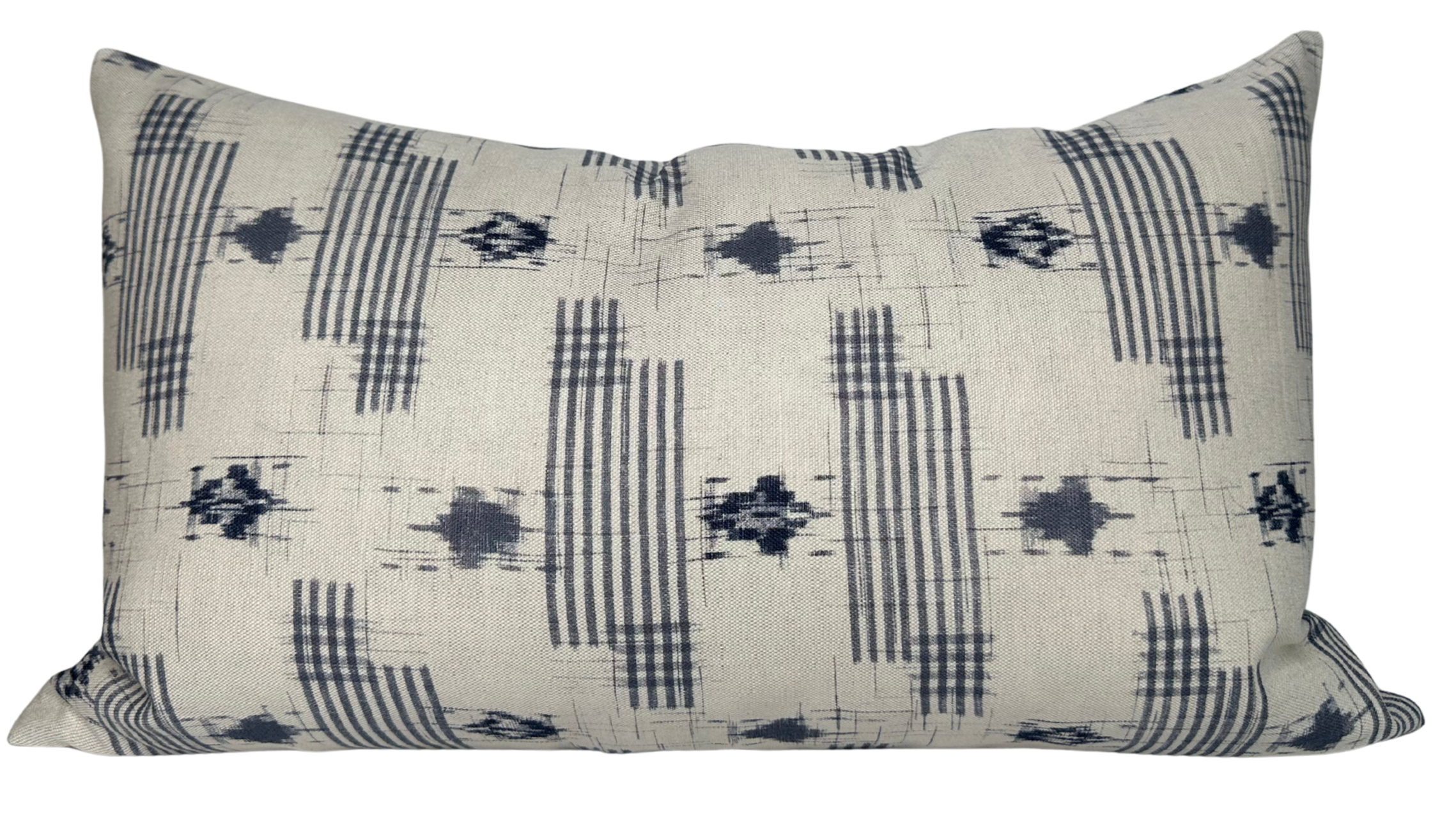 Yamato Pillow Cover in Blue laying on a sofa showing its blue printed front and ivory linen back