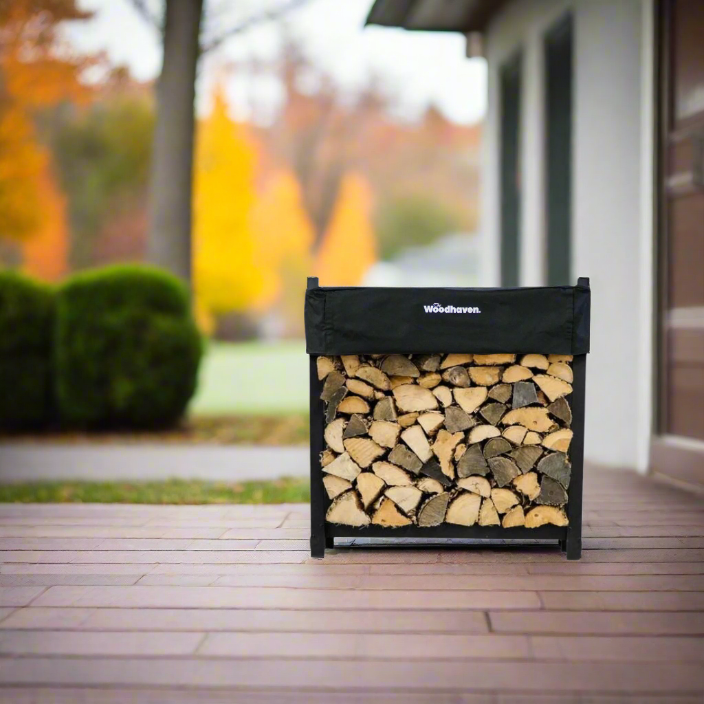 Woodhaven 3 ft Firewood Rack with seasoning cover in black finish holding stacked firewood