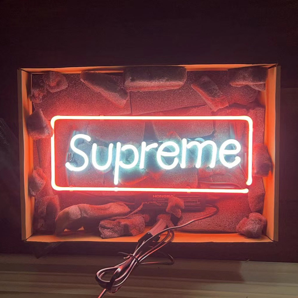 Supreme Neon Signs glowing in a darkened room on an acrylic backing