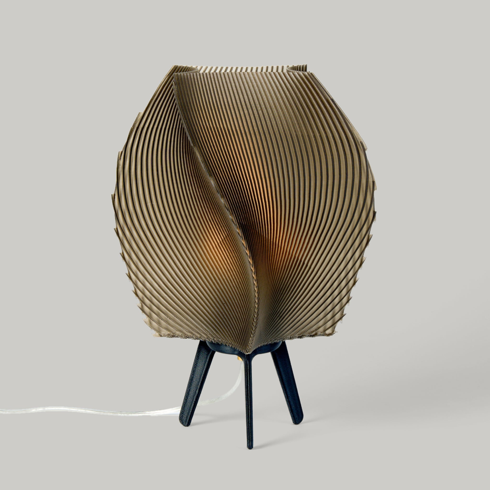 Zephyr Lamp by Wooj Design shown on a table with organic sculptural curves and textured surface