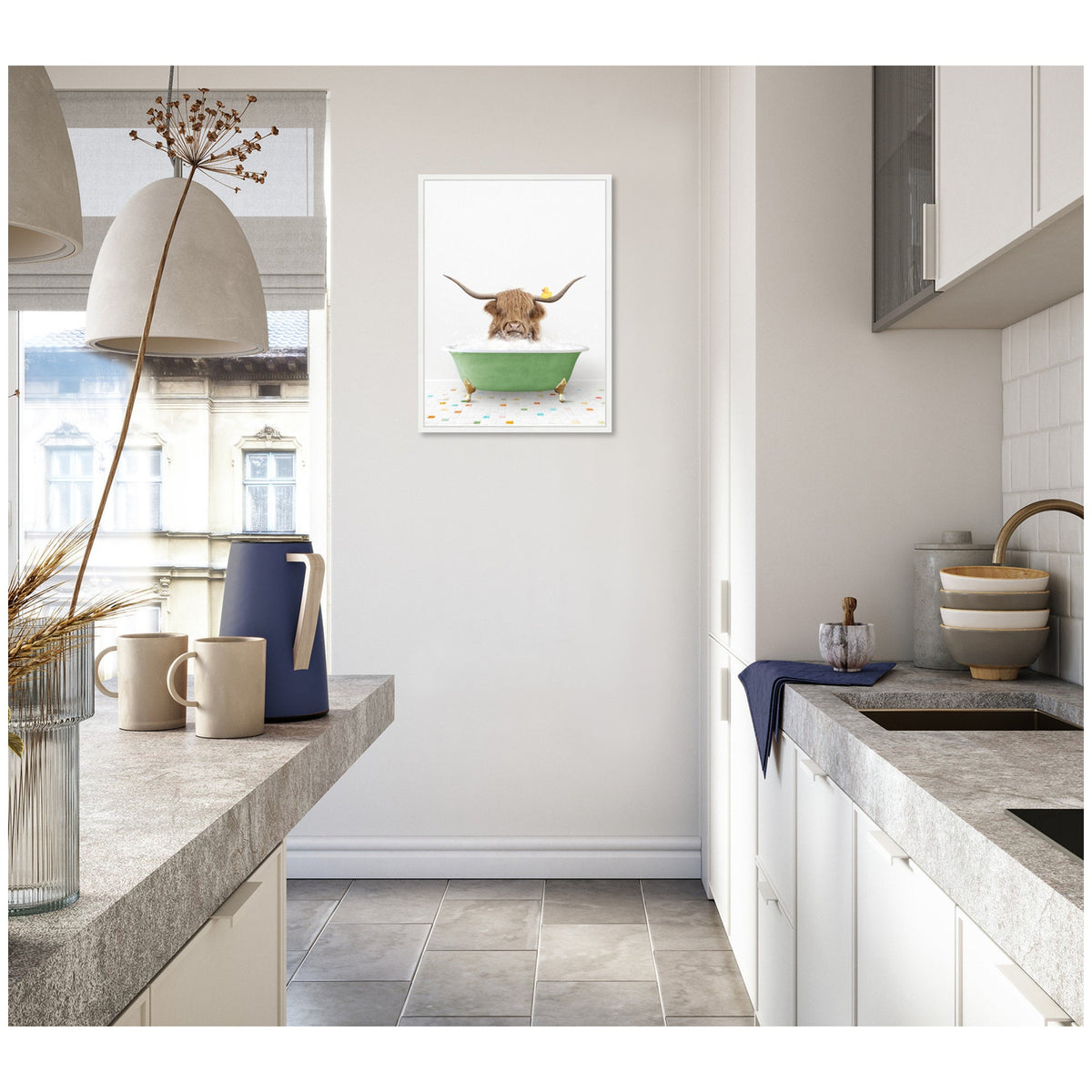 Minimalist kitchen with gray tiled floor, concrete countertops, white cabinets, and a framed canvas of a Highland cow in a green bathtub on the wall.