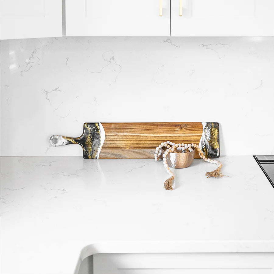 Wooden baguette resin serving tray with gold accents on a white kitchen counter