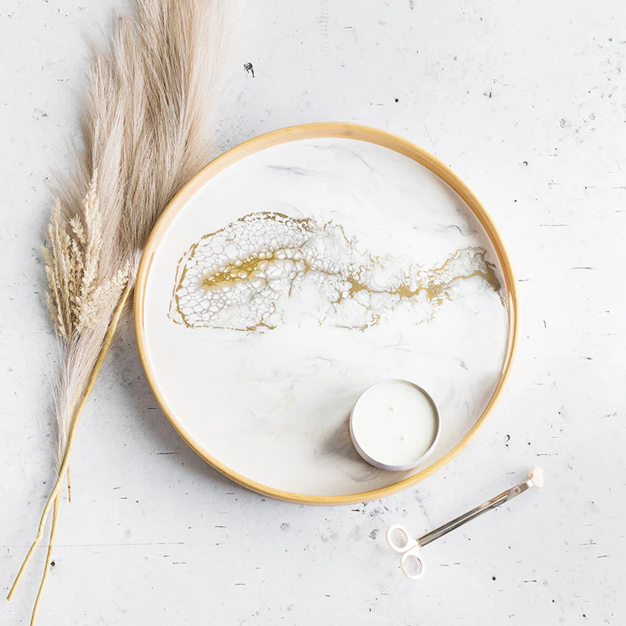 Decorative resin serving tray with gold accents on a white surface with pampas grass.