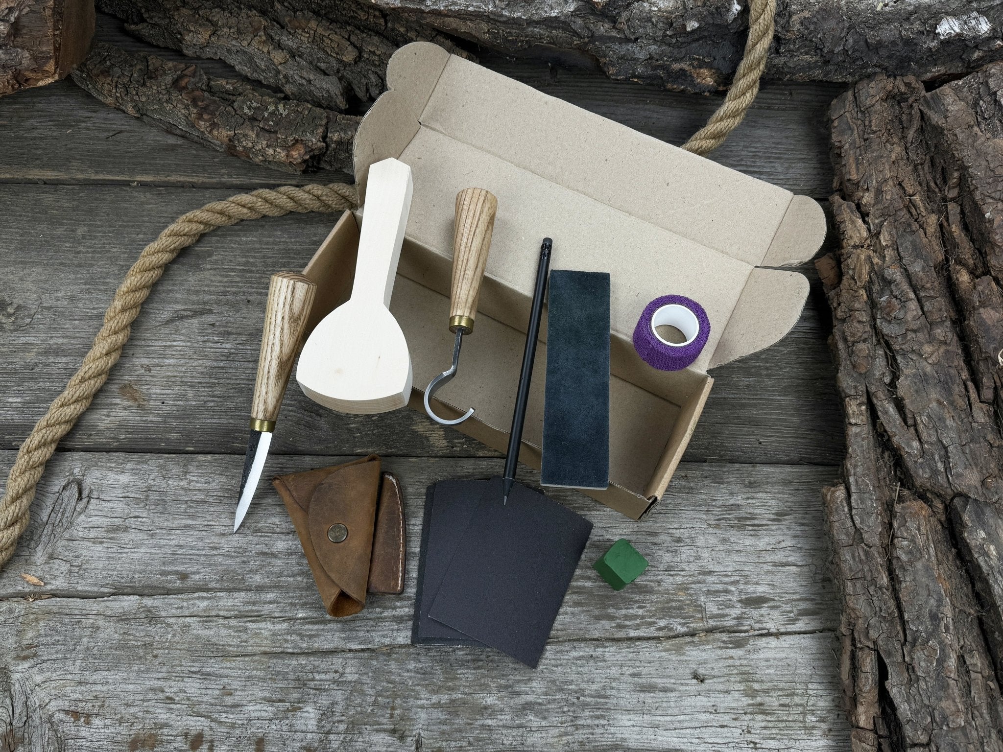 Beginner’s Spoon Carving Kit with sloyd knife, hook knife, wooden blank, sandpaper, sharpening board, pencil, and finger wrap