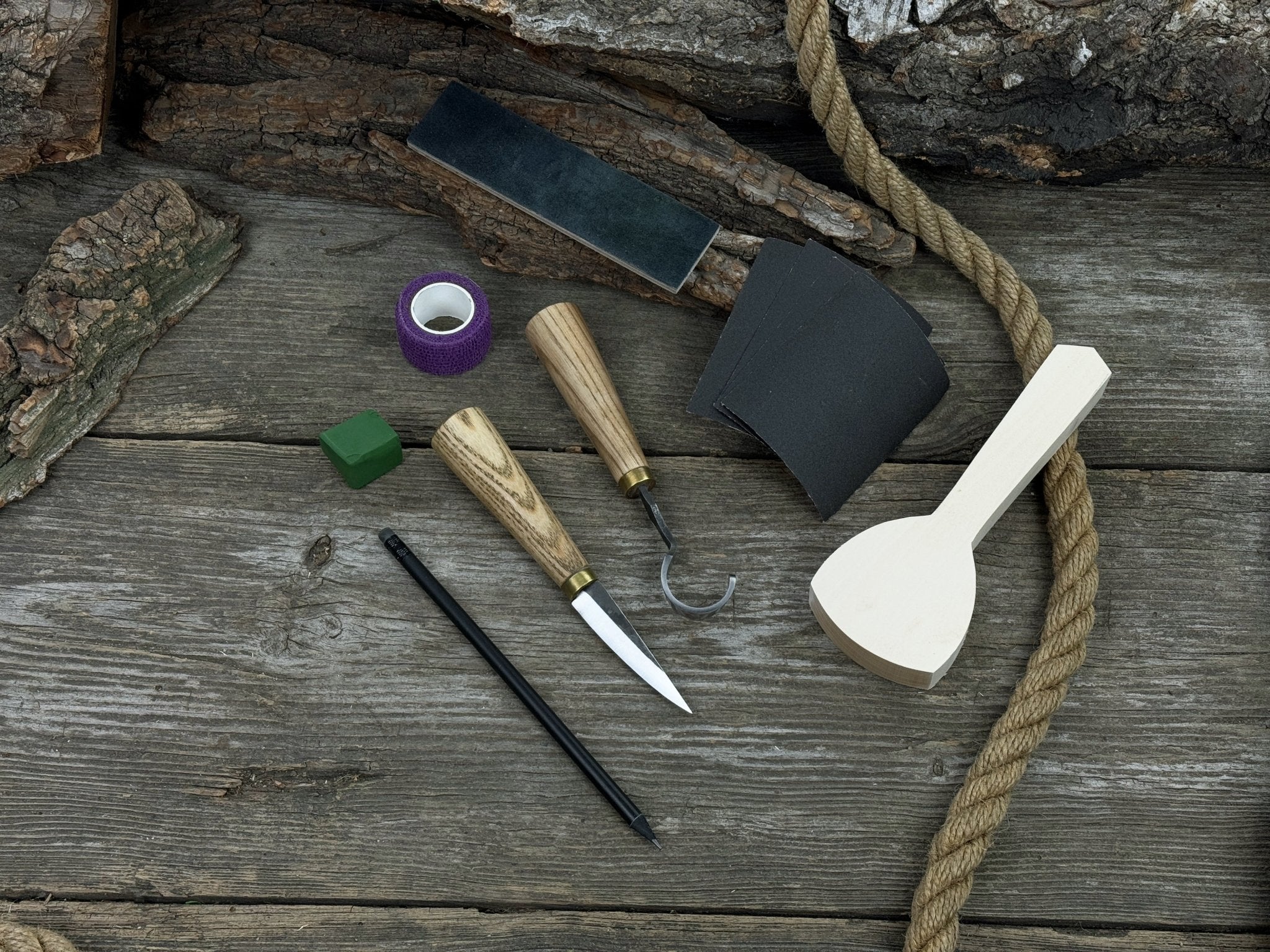 Beginner’s Spoon Carving Kit with sloyd knife, hook knife, wooden blank, sandpaper, sharpening board, pencil, and finger wrap