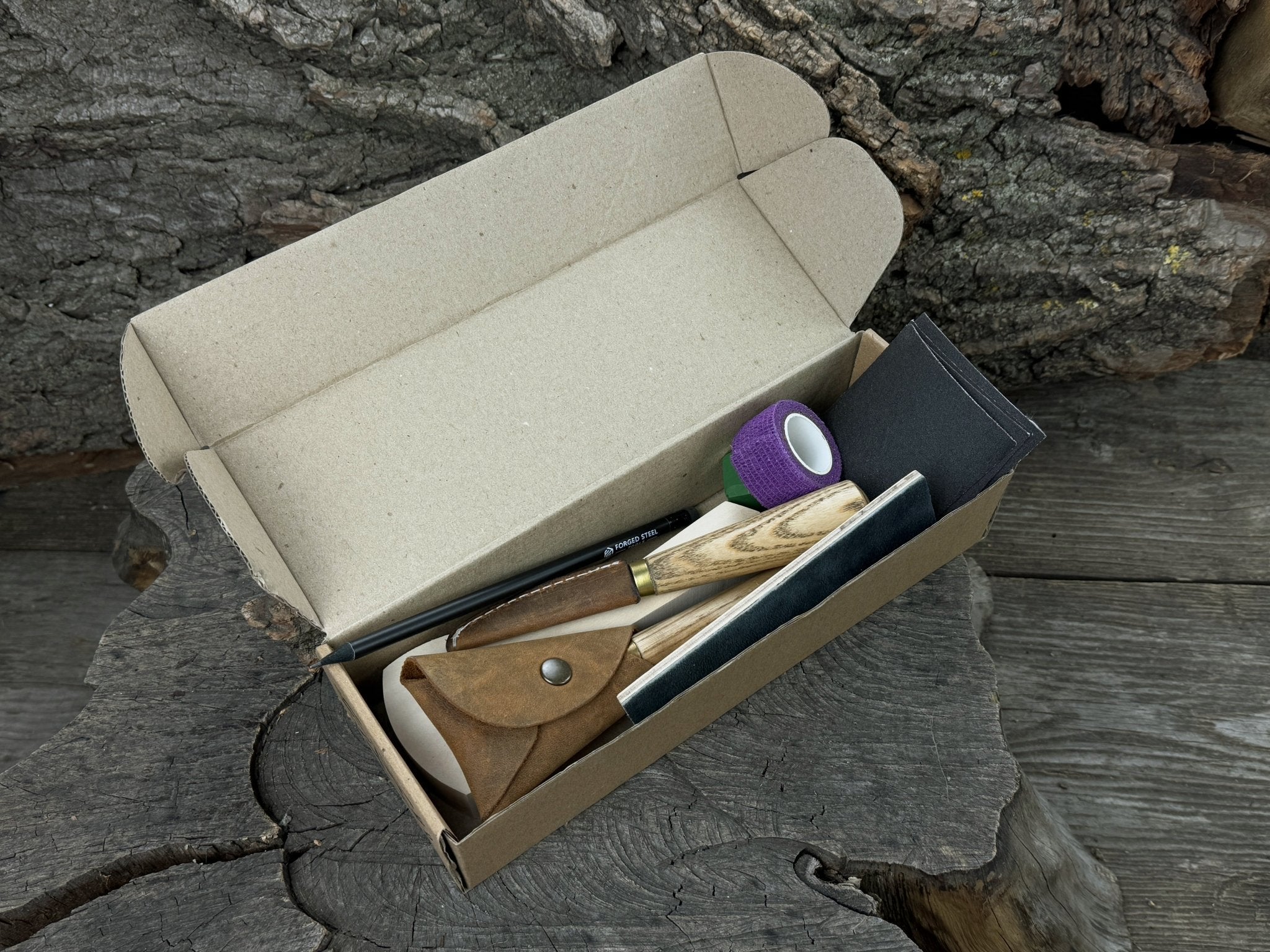 Beginner’s Spoon Carving Kit with sloyd knife, hook knife, wooden blank, sandpaper, sharpening board, pencil, and finger wrap