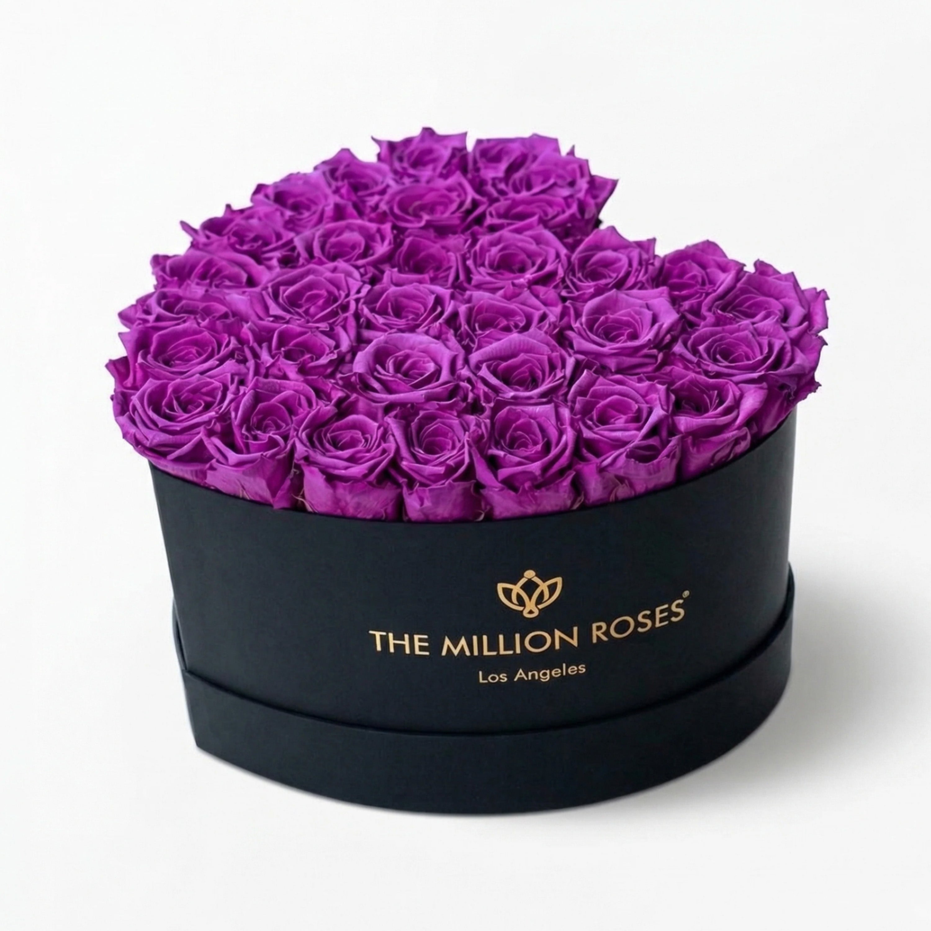 Heart-shaped black box filled with bright purple roses