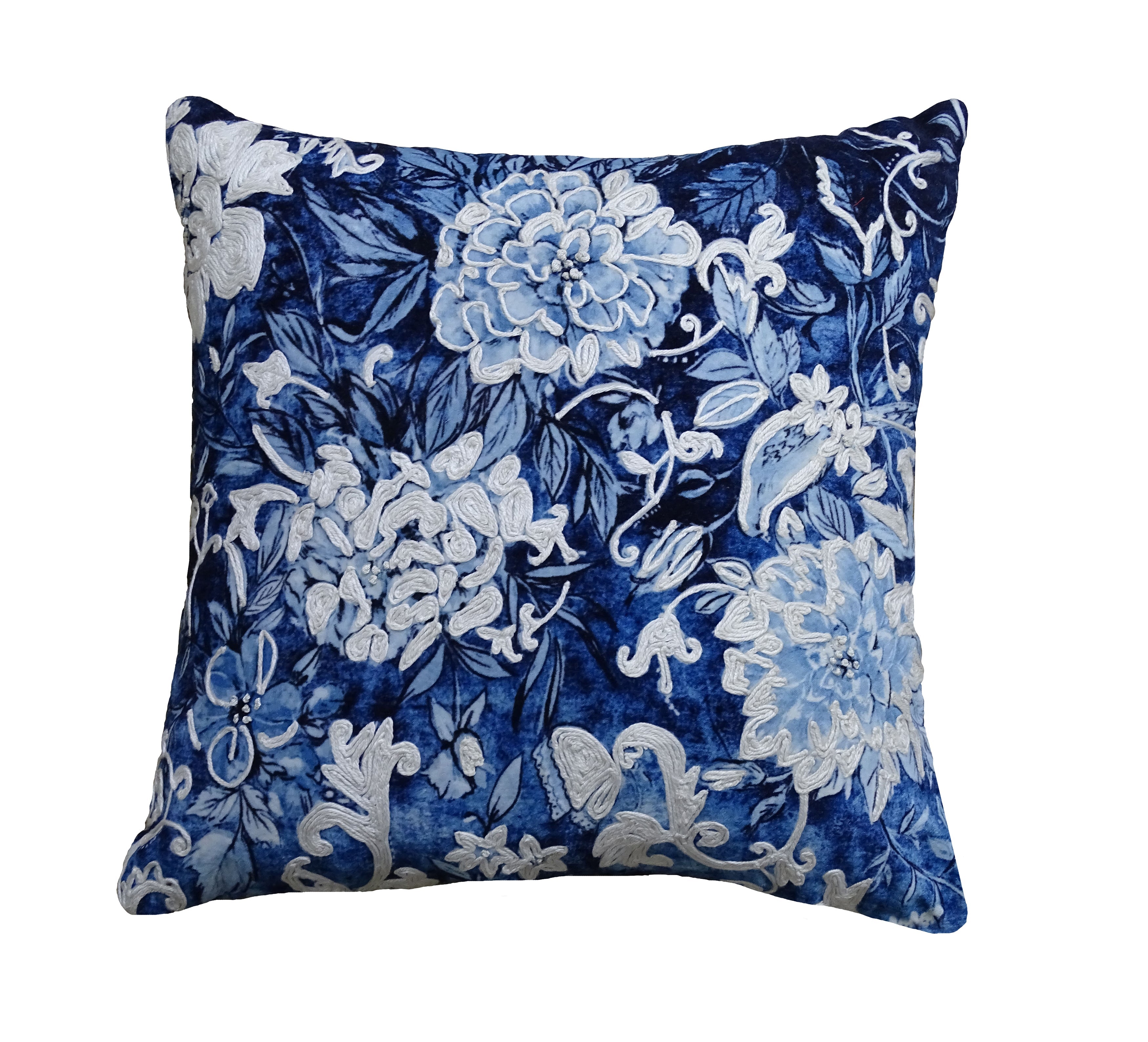 Blue and white decorative throw pillow cover with embroidered design resting on a neutral-colored couch