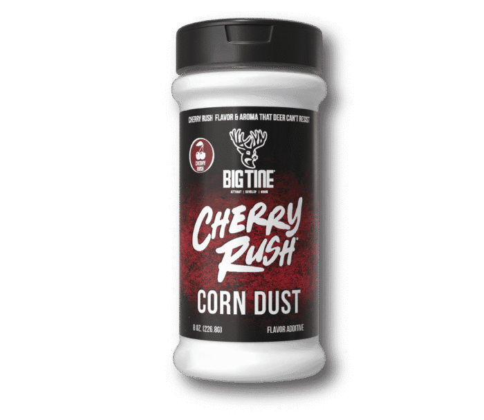 8 oz jar of Big Tine Cherry Rush Corn Dust with scattered corn kernels