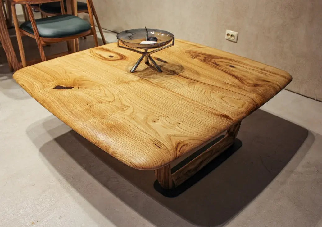 Rustic solid chestnut wood coffee table with chestnut legs in living room setting