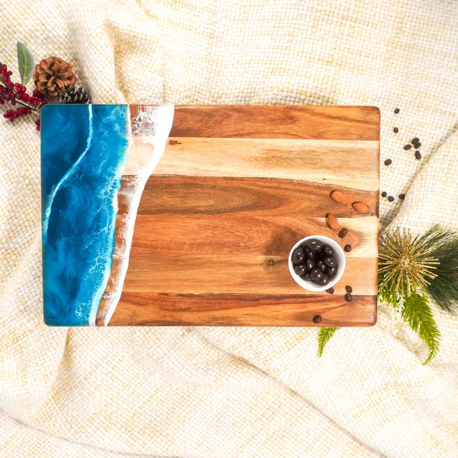 acacia resin serving bread board with blue resin design on a textured surface