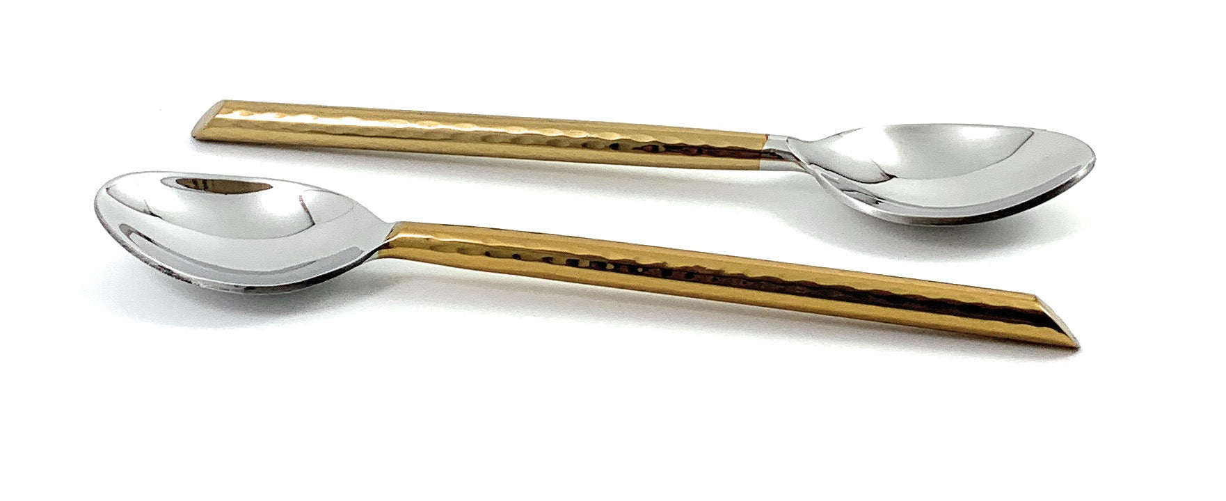 Set of six golden teaspoons with hammered handles laid out on a surface