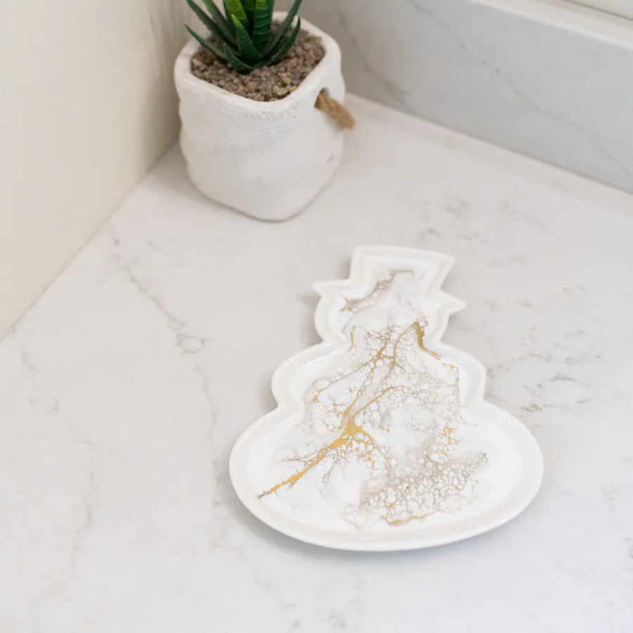Resin Ceramic Snowman Tray on a marble surface with a potted plant in the background.
