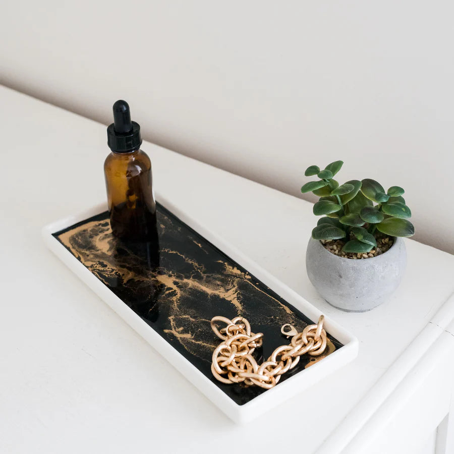 Marble-patterned Small Ceramic Resin Tray with a bottle, gold chain, and small plant on a white surface