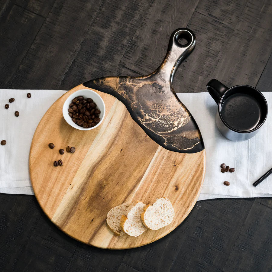 Wooden Cheese Paddle Acacia Serving Charcuterie Board with a black handle, bowl of coffee beans, and slices of bread on a dark surface.