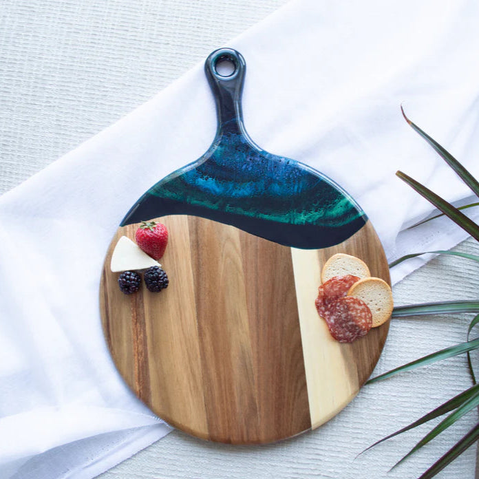 Wooden Cheese Paddle Acacia Serving Charcuterie Board with a decorative handle on a white surface with food items.