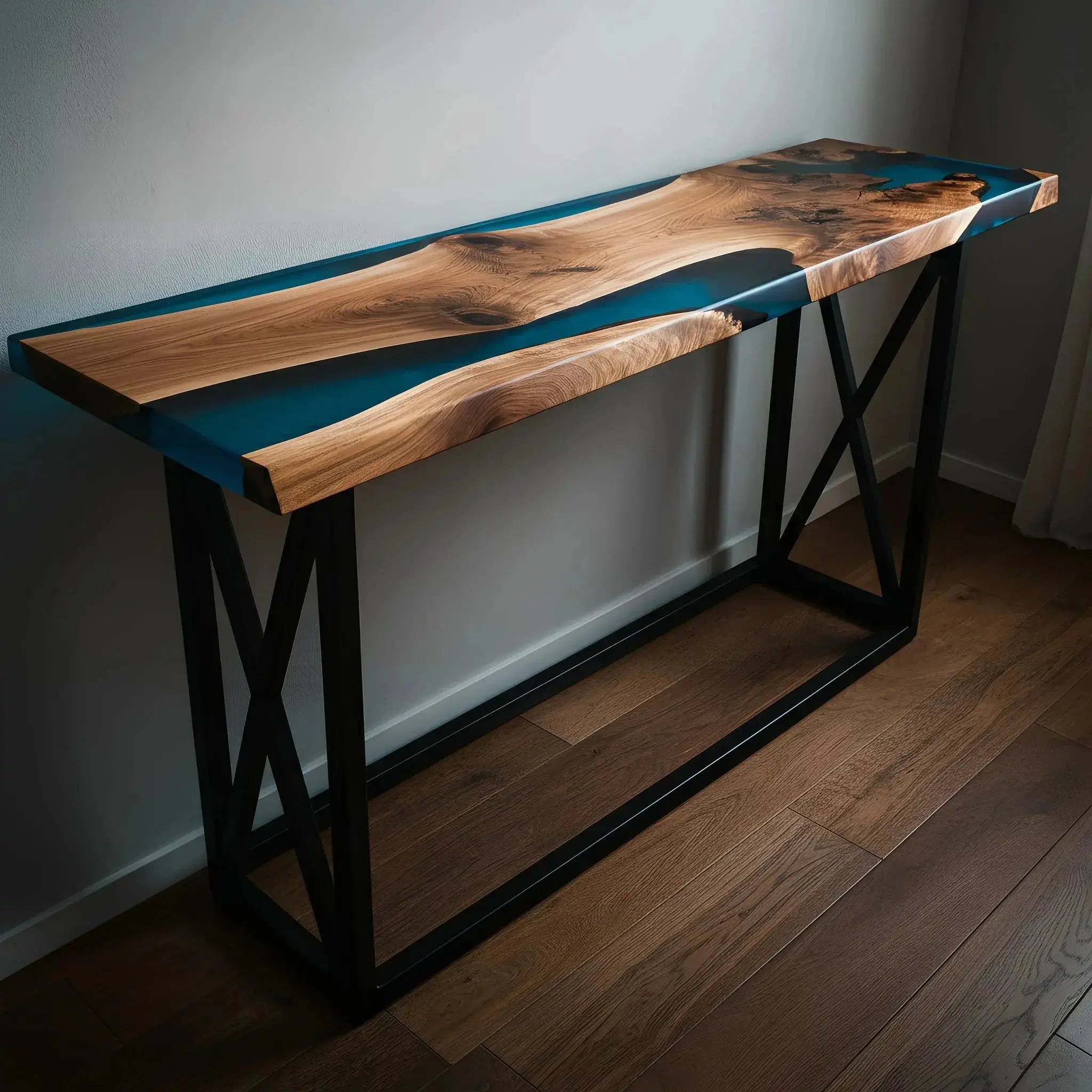 Handcrafted epoxy river console table with crisscross metal legs, featuring rich walnut wood and deep blue resin for a coastal-modern aesthetic.