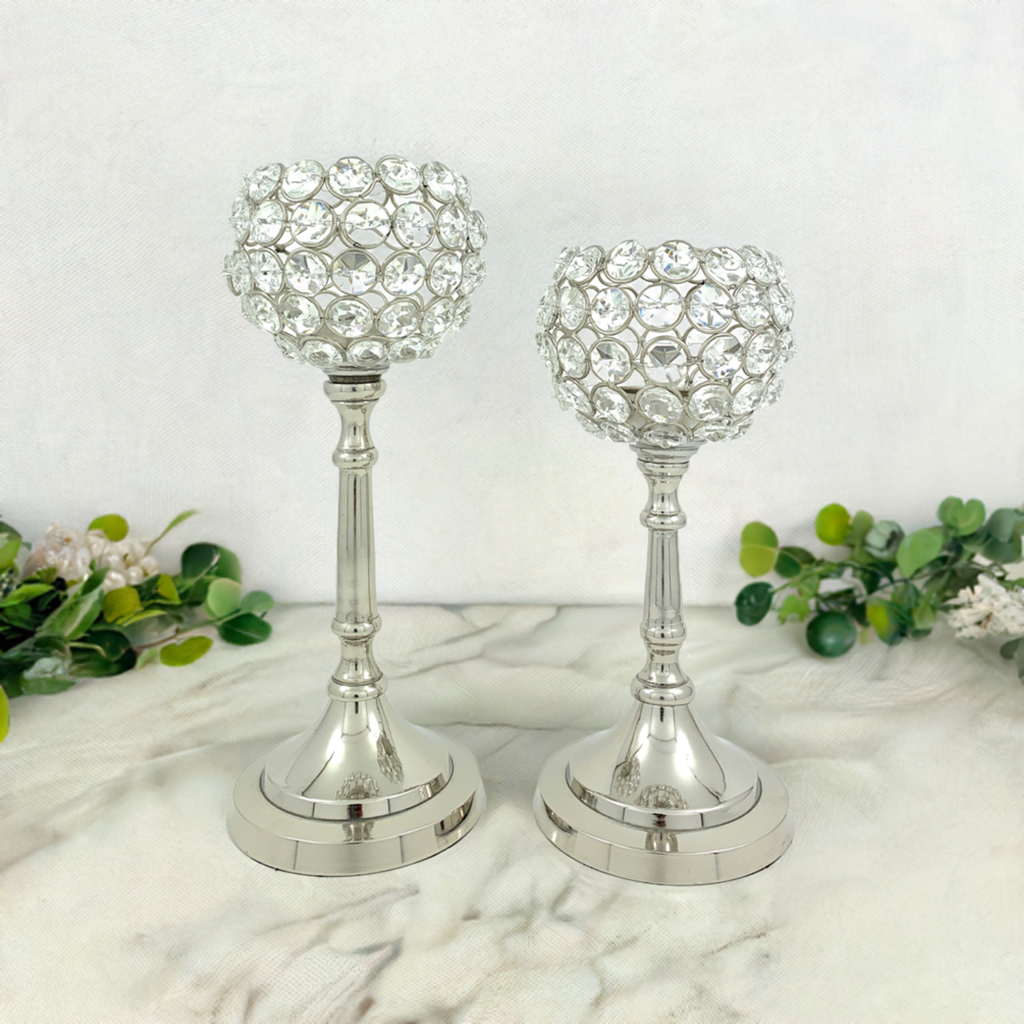 Vibhsa Hurricane set of two crystal candle holders placed with tea light candles, showing silver nickel aluminum bases and crystal accents.