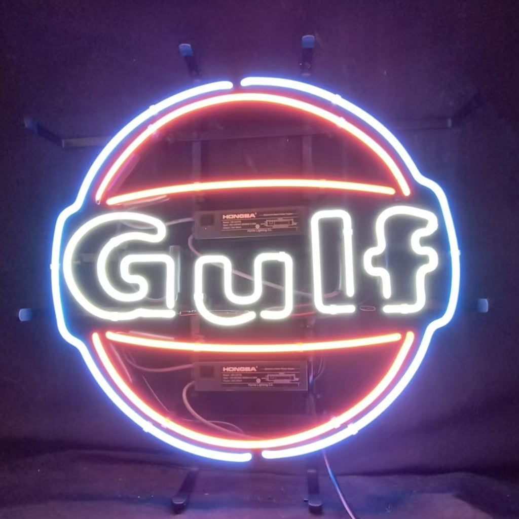 Gulf Gasoline Neon Sign glowing against dark indoor wall with metal grid backing