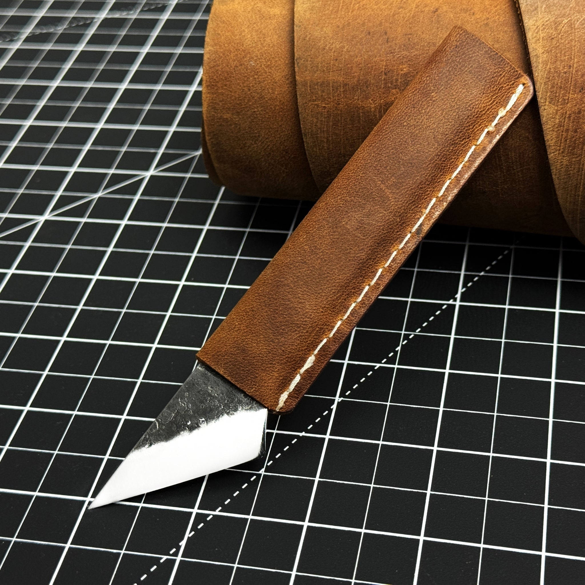 Hand-forged kiridashi knife with razor-sharp carbon steel blade and leather sheath
