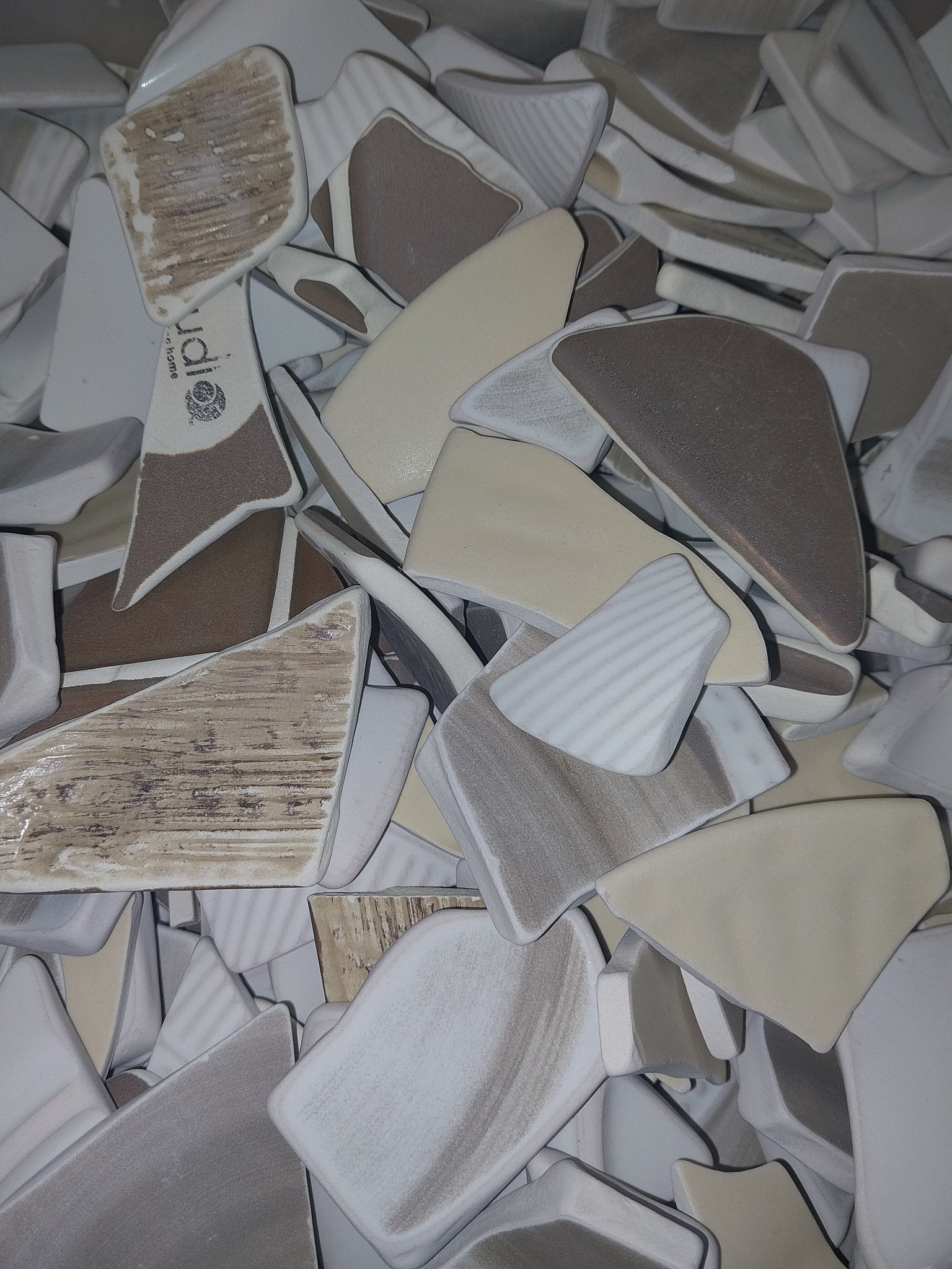 Assorted hand-tumbled pottery pieces in earthy colors for mosaic crafts