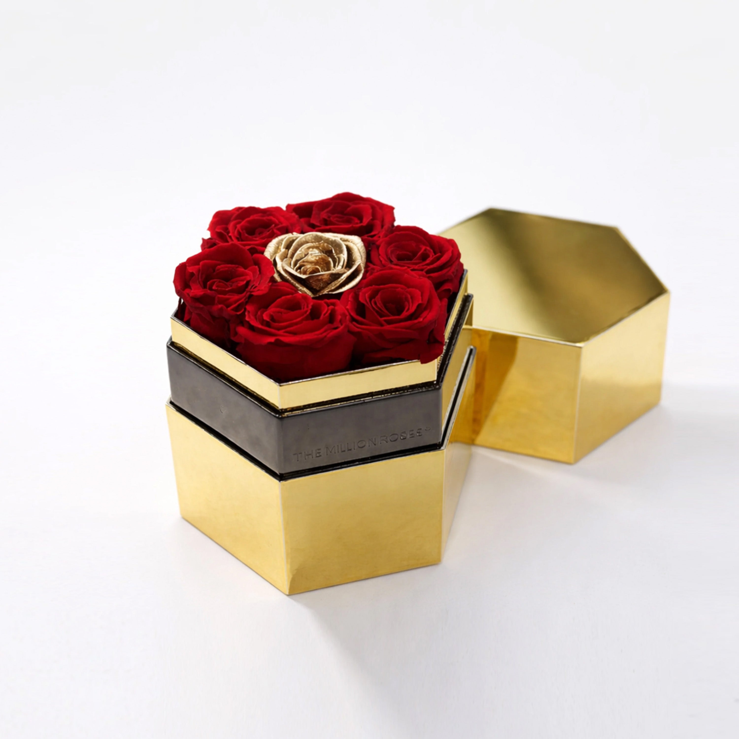 Gold hexagon box with one large red and gold rose inside, showing mirrored facets and clean geometric lines