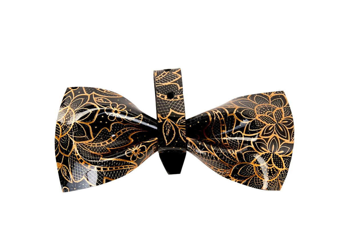 Black and gold floral print patent Italian leather bowtie displayed on white fabric background