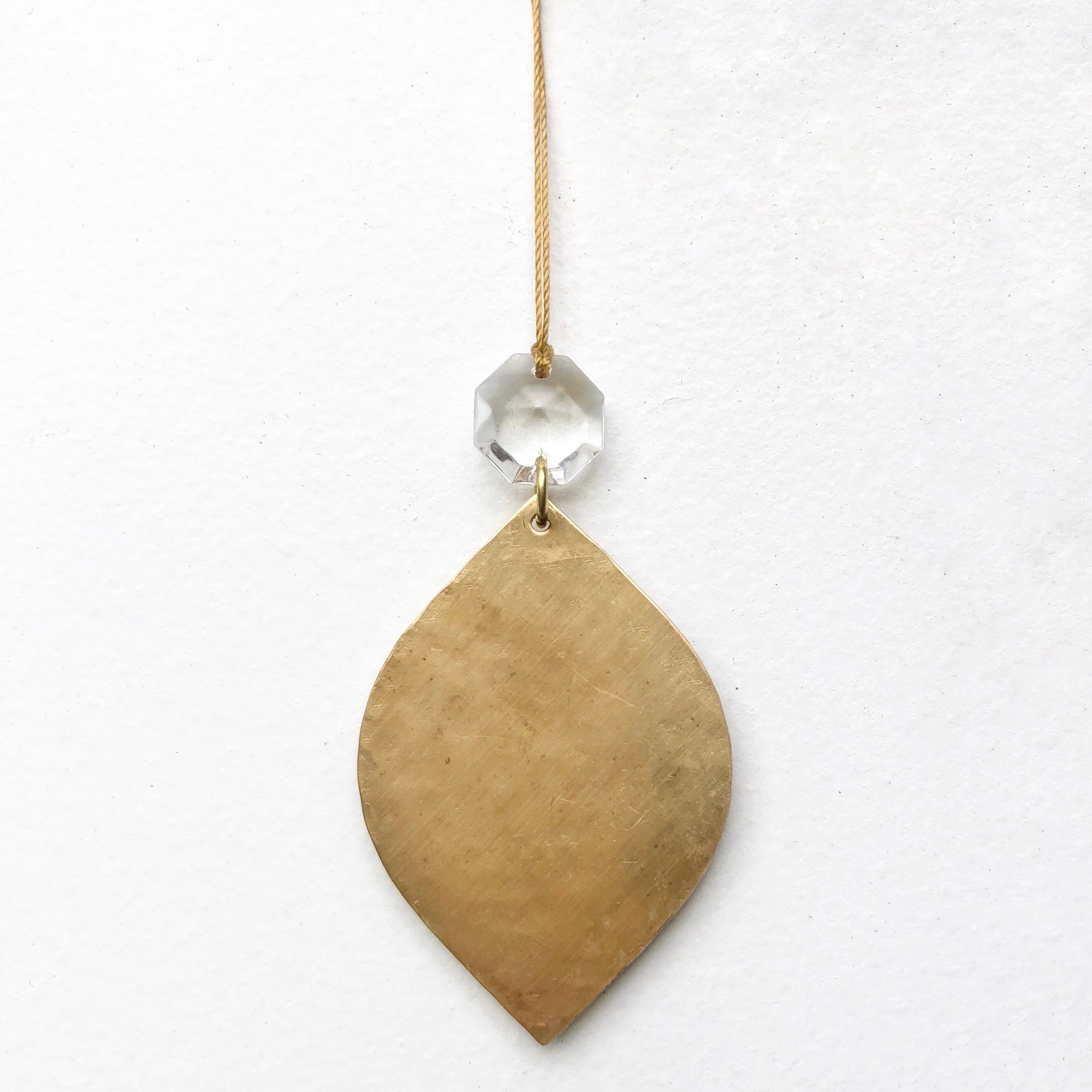 Noël Ornament With Vintage Glass Crystal hanging on a branch with brass frame and clear vintage glass crystal detail