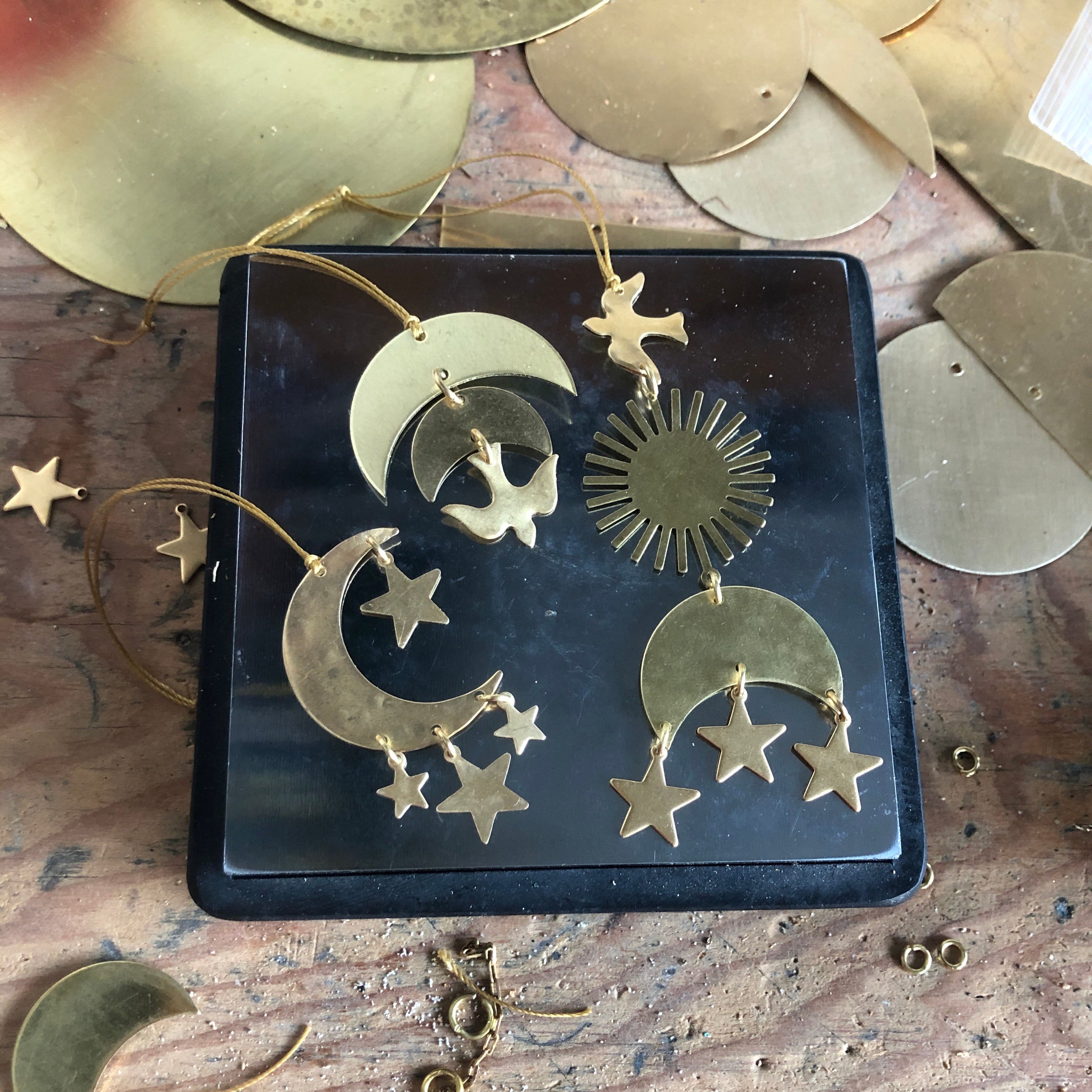 Guardian Ornament by Vida + Luz hand-hammered brass ornament hanging on white wall