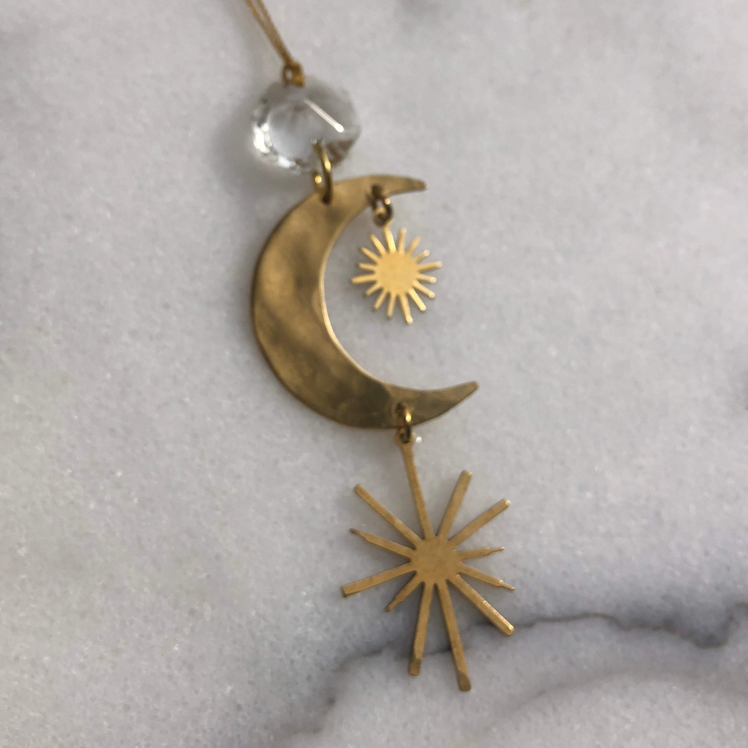 Hand-cut and hammered brass Stargazer ornament with a vintage glass crystal hanging by a cord