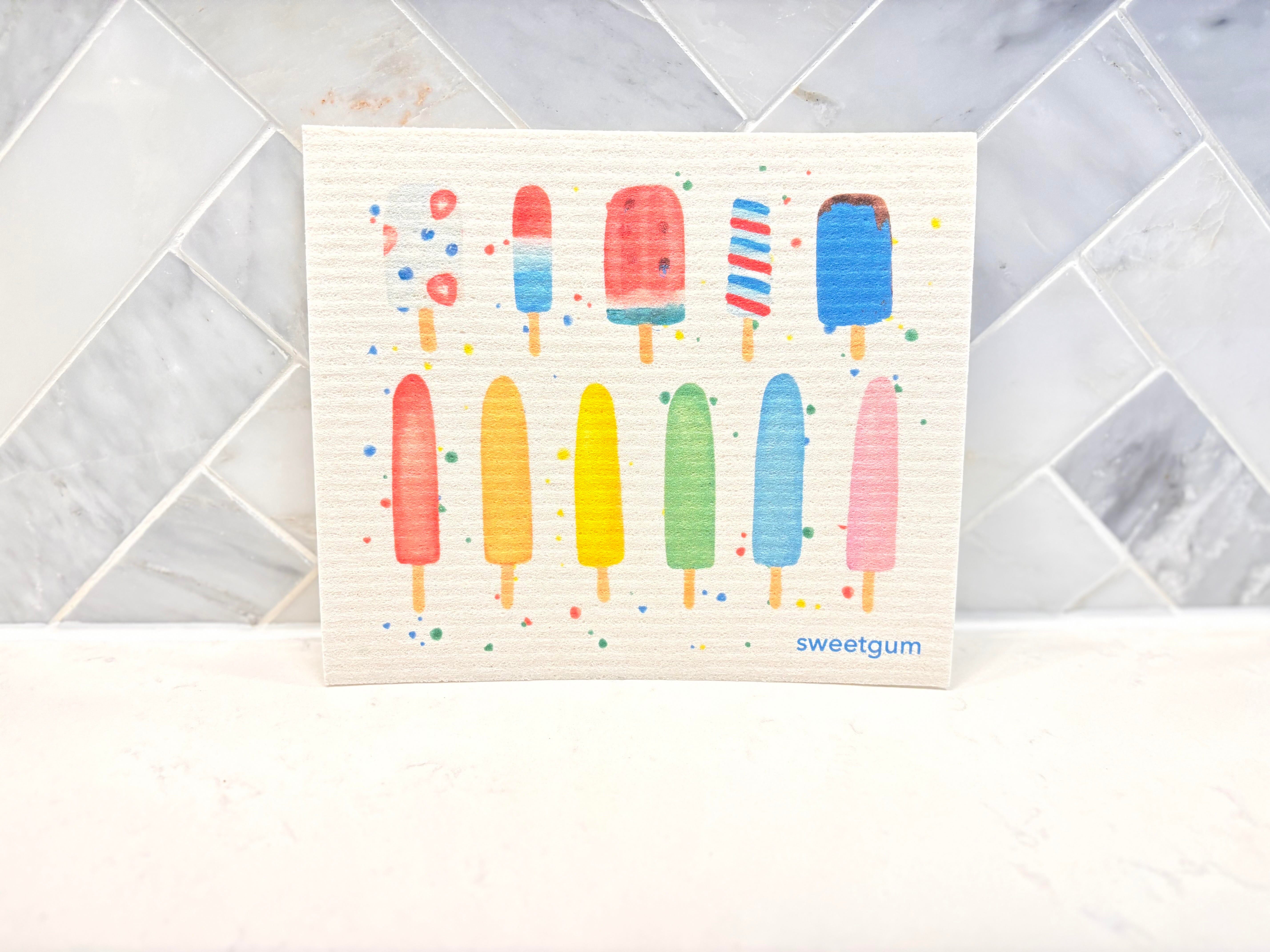 Swedish dishcloth with colorful popsicles print laid flat