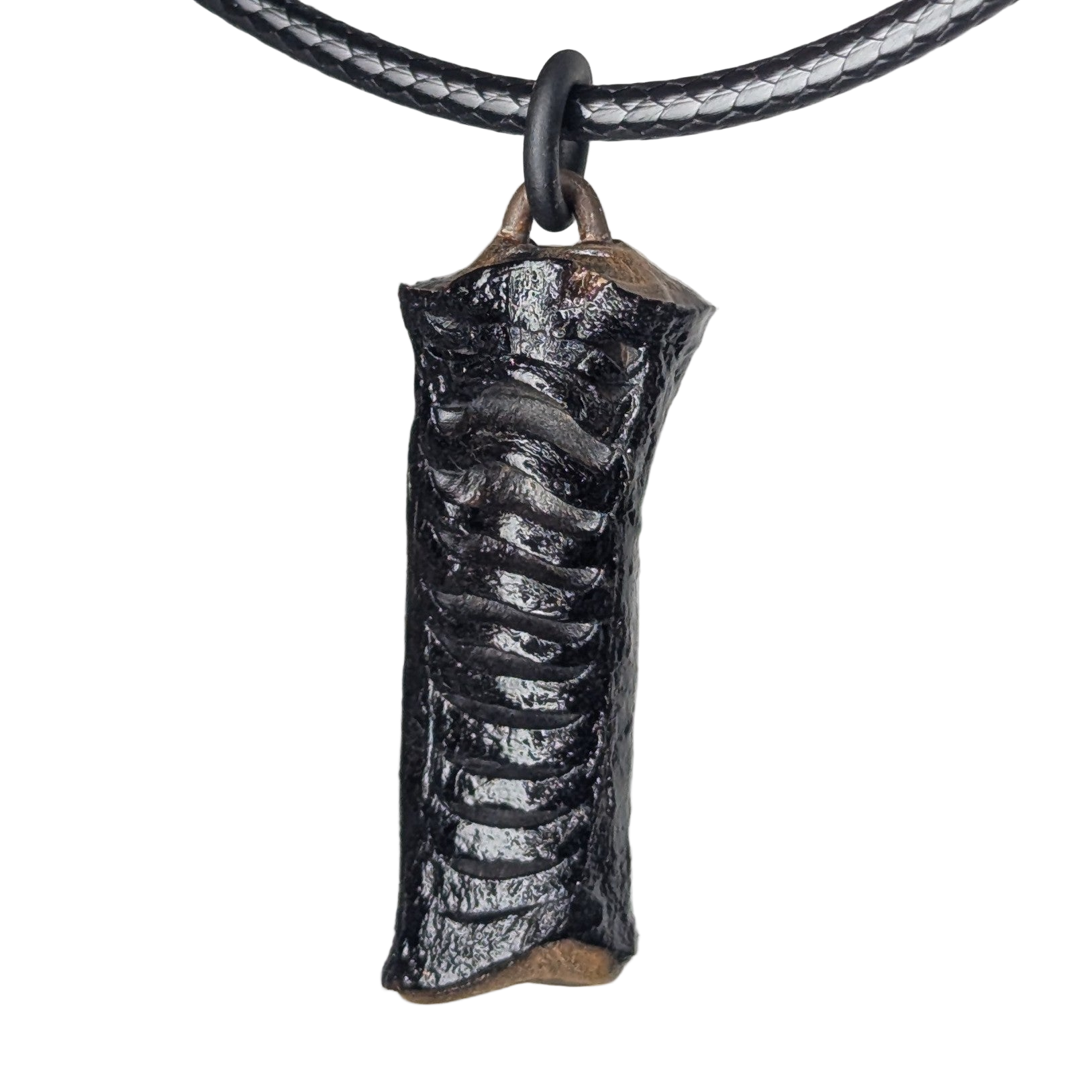 Calyra pendant necklace by Versiliy photographed on a dark surface with natural lighting