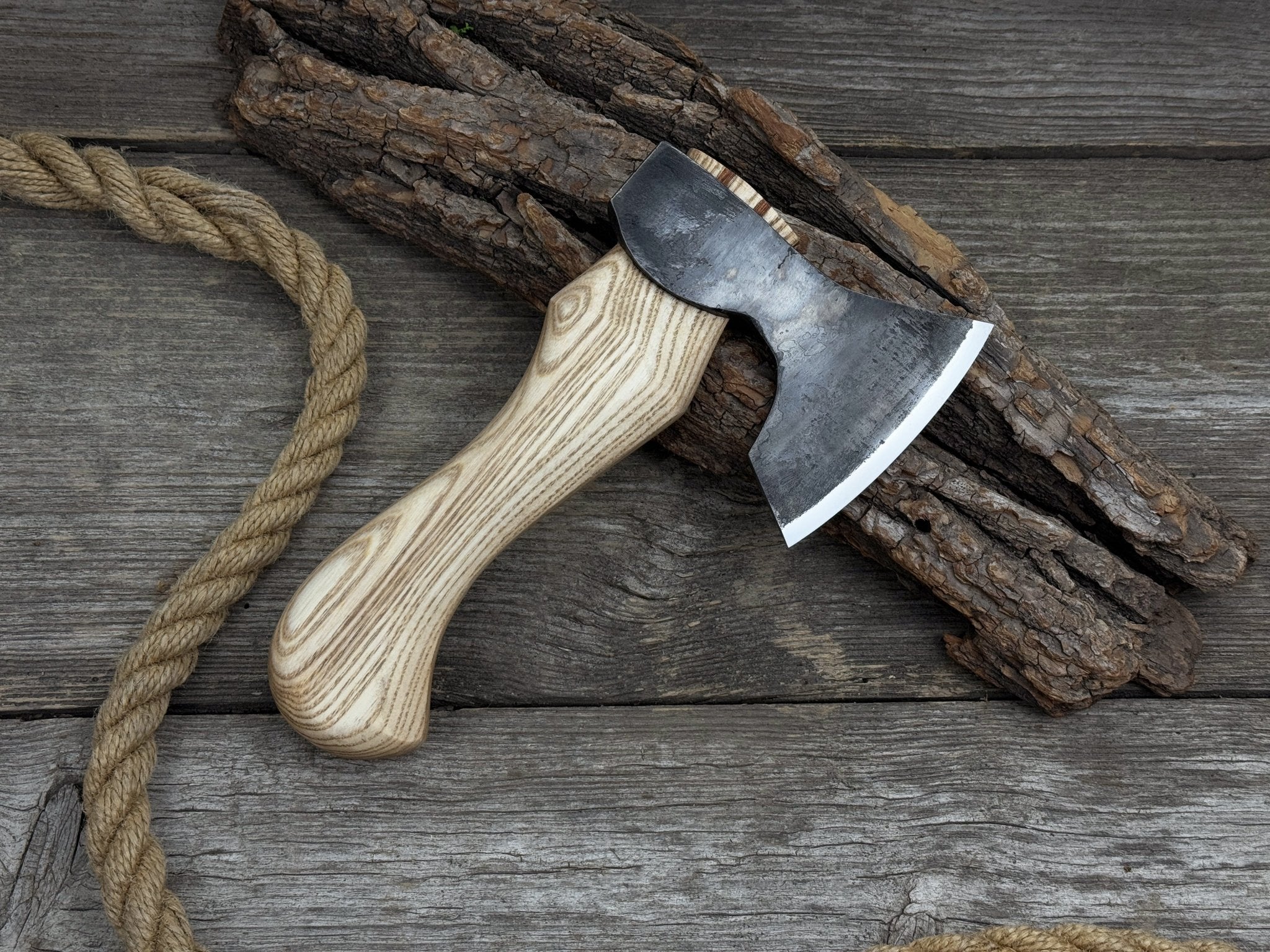 Small carving axe with carbon steel blade and ash wood handle, featuring leather sheath with belt loop