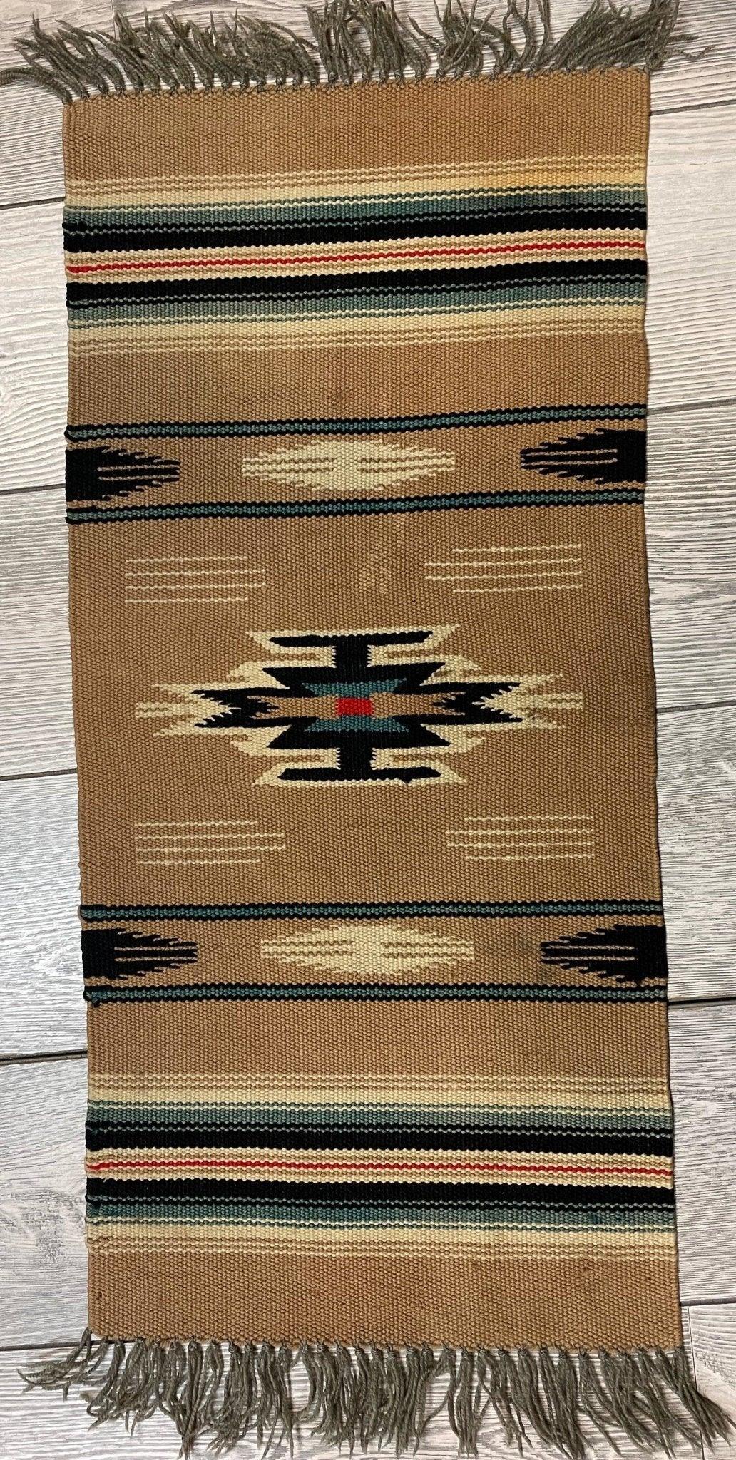 Small Mexican hand-woven kilim rug with geometric pattern in muted earth tones, measuring 14 by 30 inches