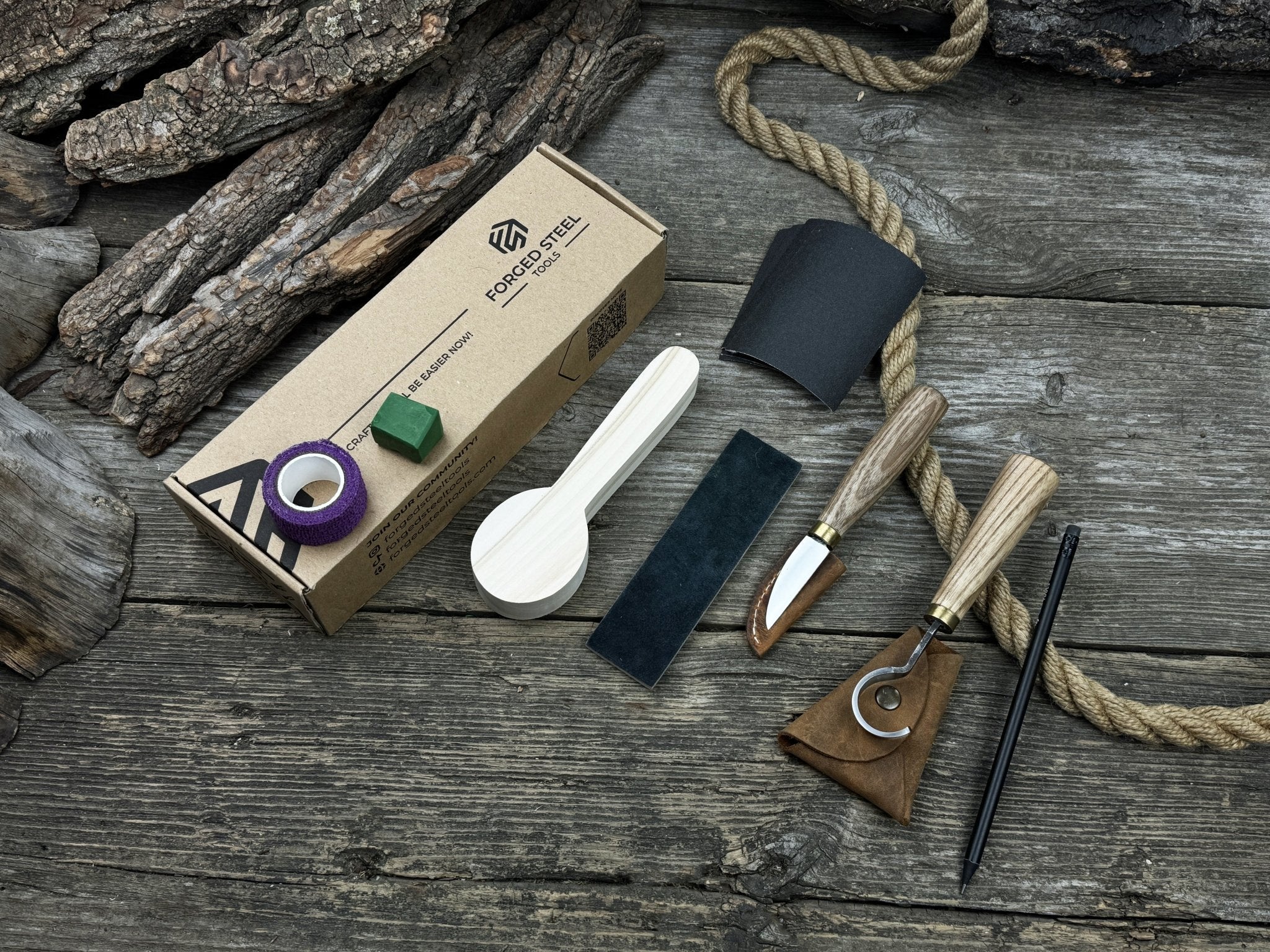 Spoon Carving Kit with knives, wooden blank, sandpaper, sharpening board, pencil, and finger wrap