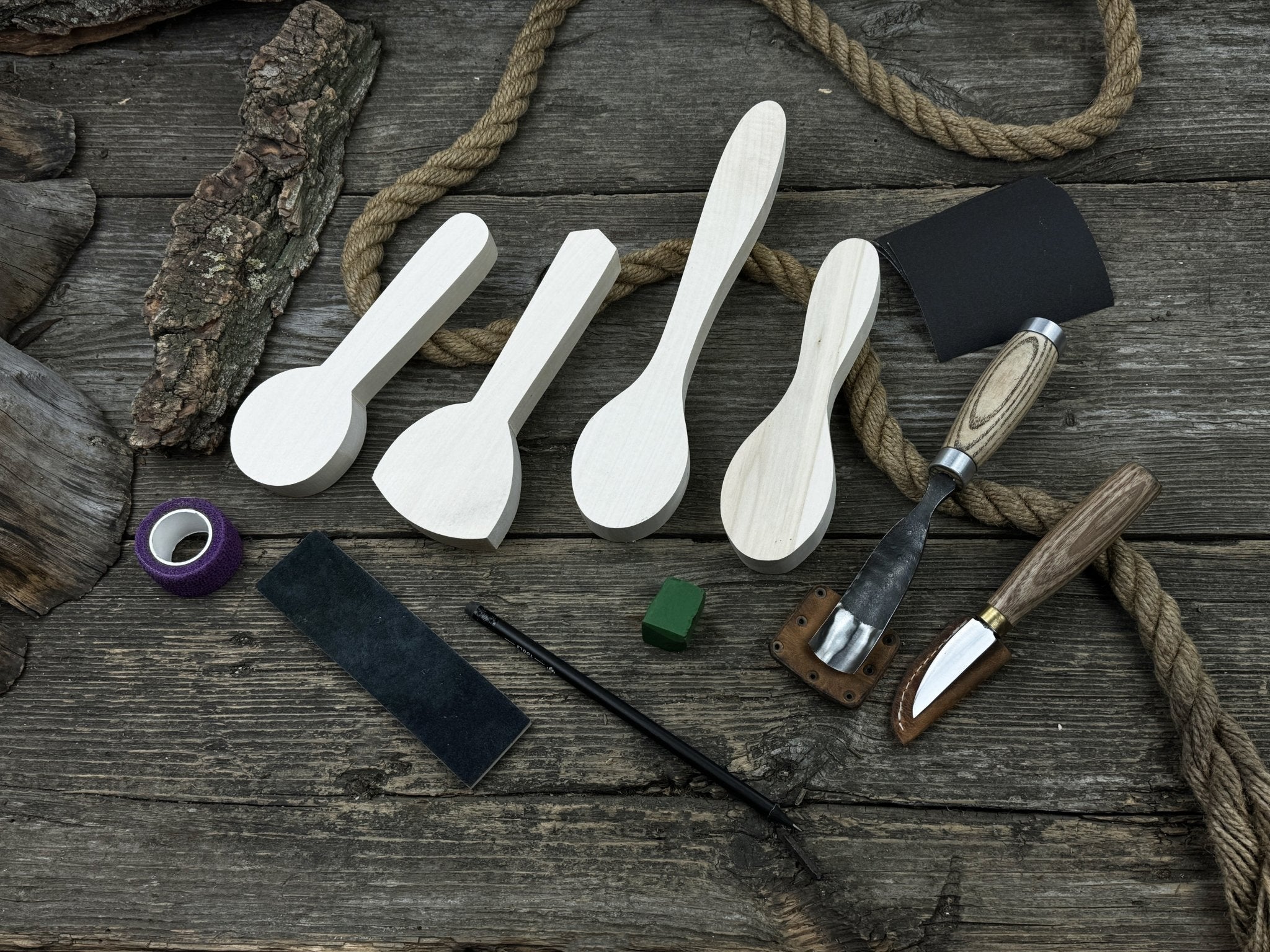 Spoon Carving Kit with hand-forged tools, wooden blanks, sandpaper, and sharpening board