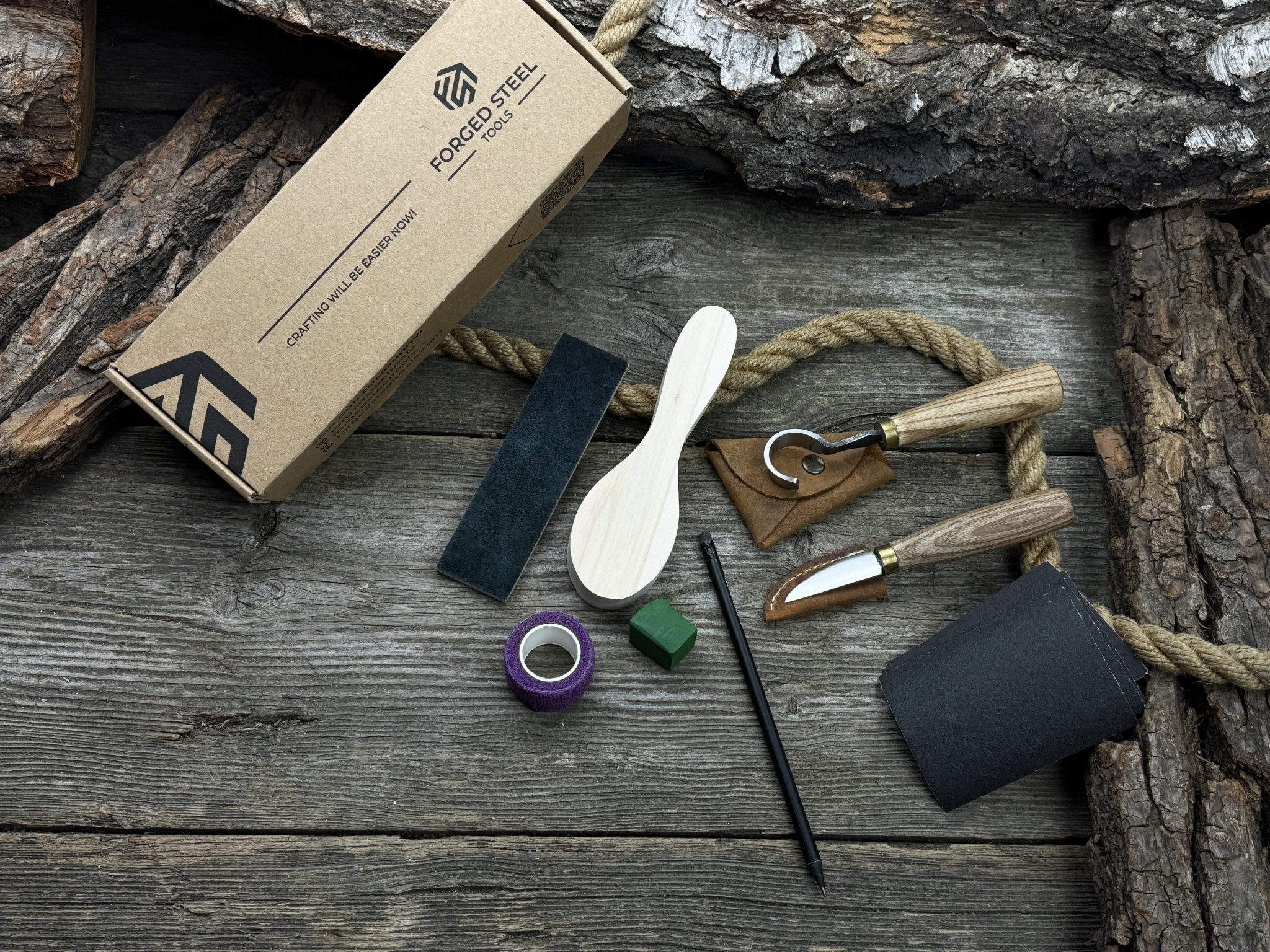 Spoon Carving Kit with knives, wooden blank, sandpaper, sharpening board, pencil, and finger wrap