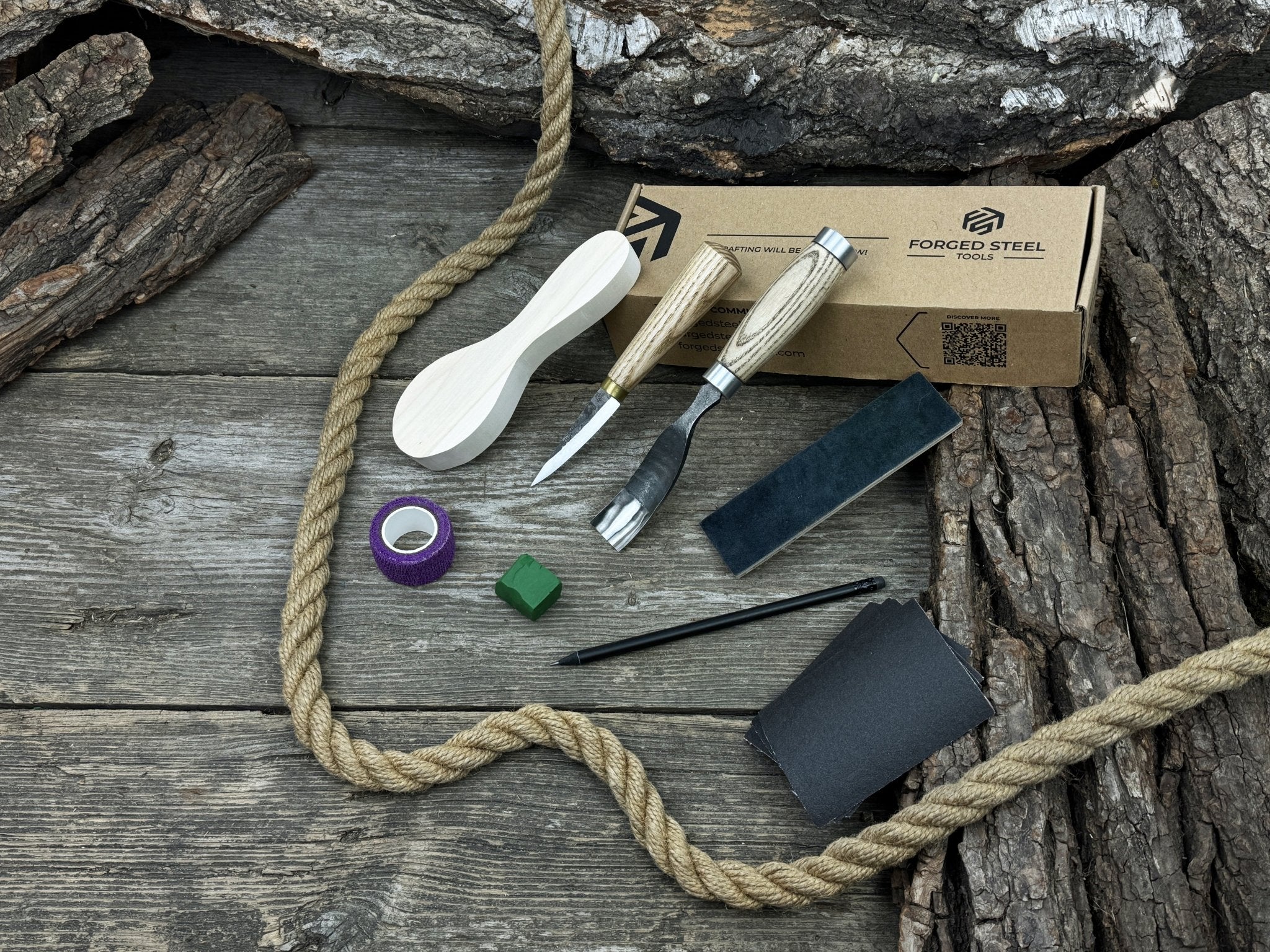 Spoon carving kit with sharpened tools, wooden blank, sandpaper, sharpening board, pencil, and finger wrap