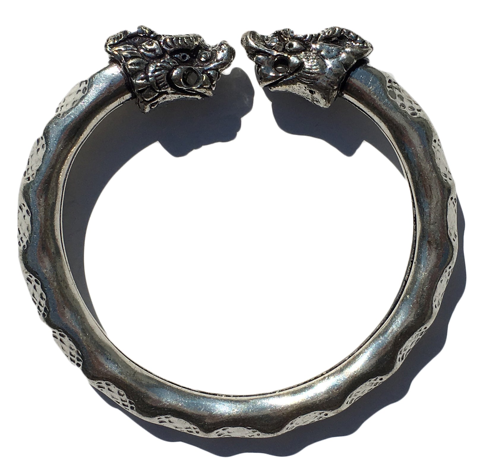 Antique Norse Viking Bracelet showing two lion heads twisting around with waved pattern on white background